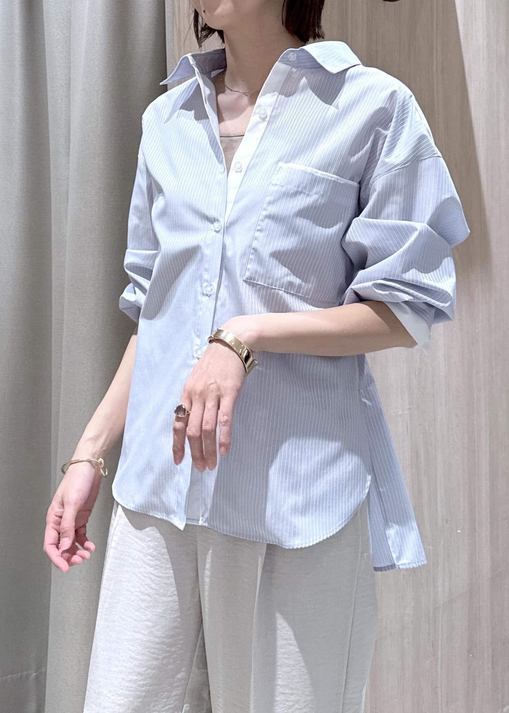 ベージュ系のキャミソール、ブラック系のショルダーバッグ、ブルー系のシャツ/ブラウスを着用したレディースの春コーディネートの7枚目の写真