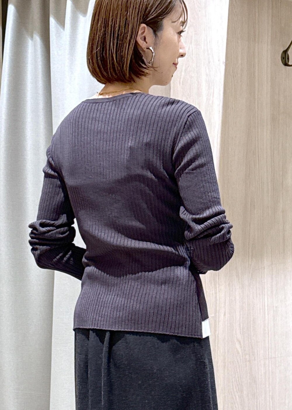 ブラック系のキャミソール、ブラック系のパンプス、グレー系のスカートを着用したレディースの秋コーディネートの10枚目の写真