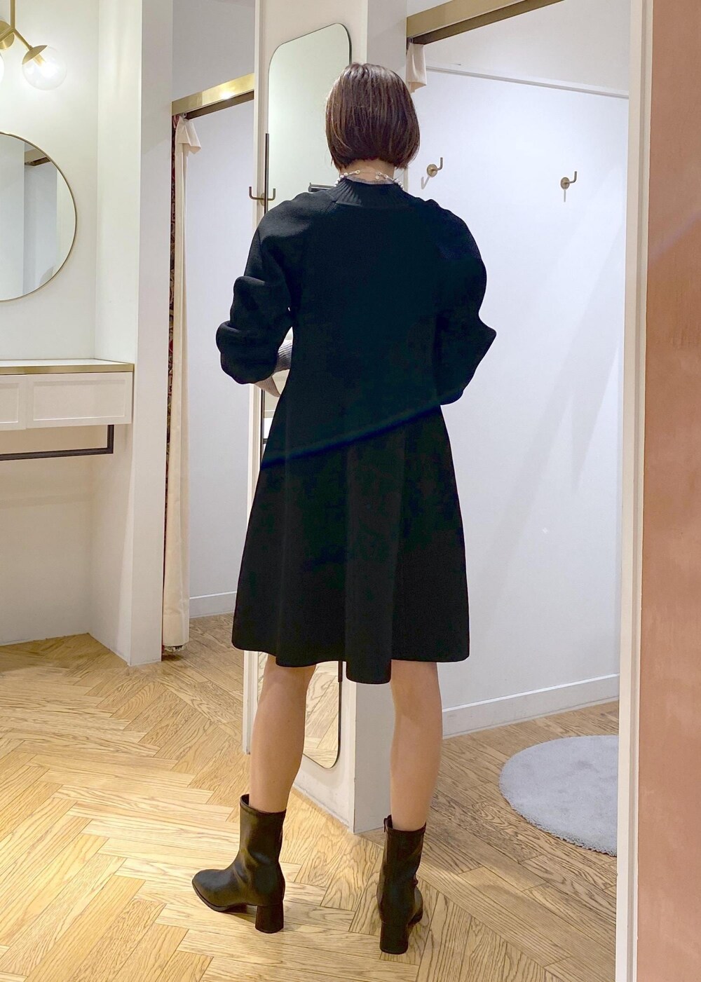 ブラック系のブーツ、ブラック系のワンピース、グレー系のニット/セーターを着用したレディースの秋コーディネートの3枚目の写真