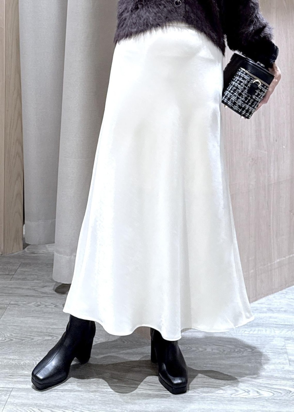 ブラック系のブーツ、ホワイト系のスカート、グレー系のカーディガン/ボレロを着用したレディースの冬コーディネートの8枚目の写真