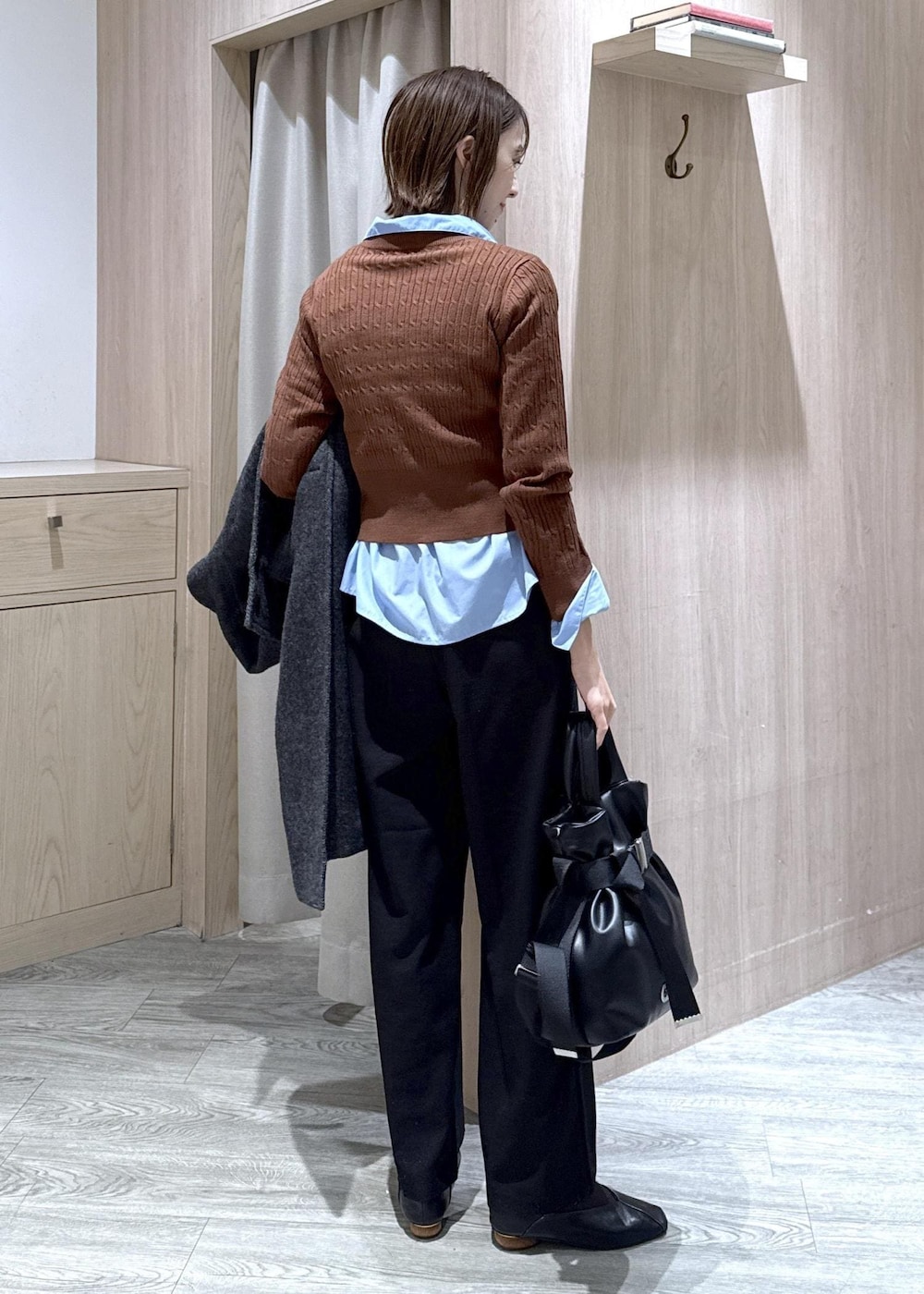 ブラック系のスラックス、グレー系のその他アウター、ブルー系のシャツ/ブラウスを着用したレディースの冬コーディネートの4枚目の写真