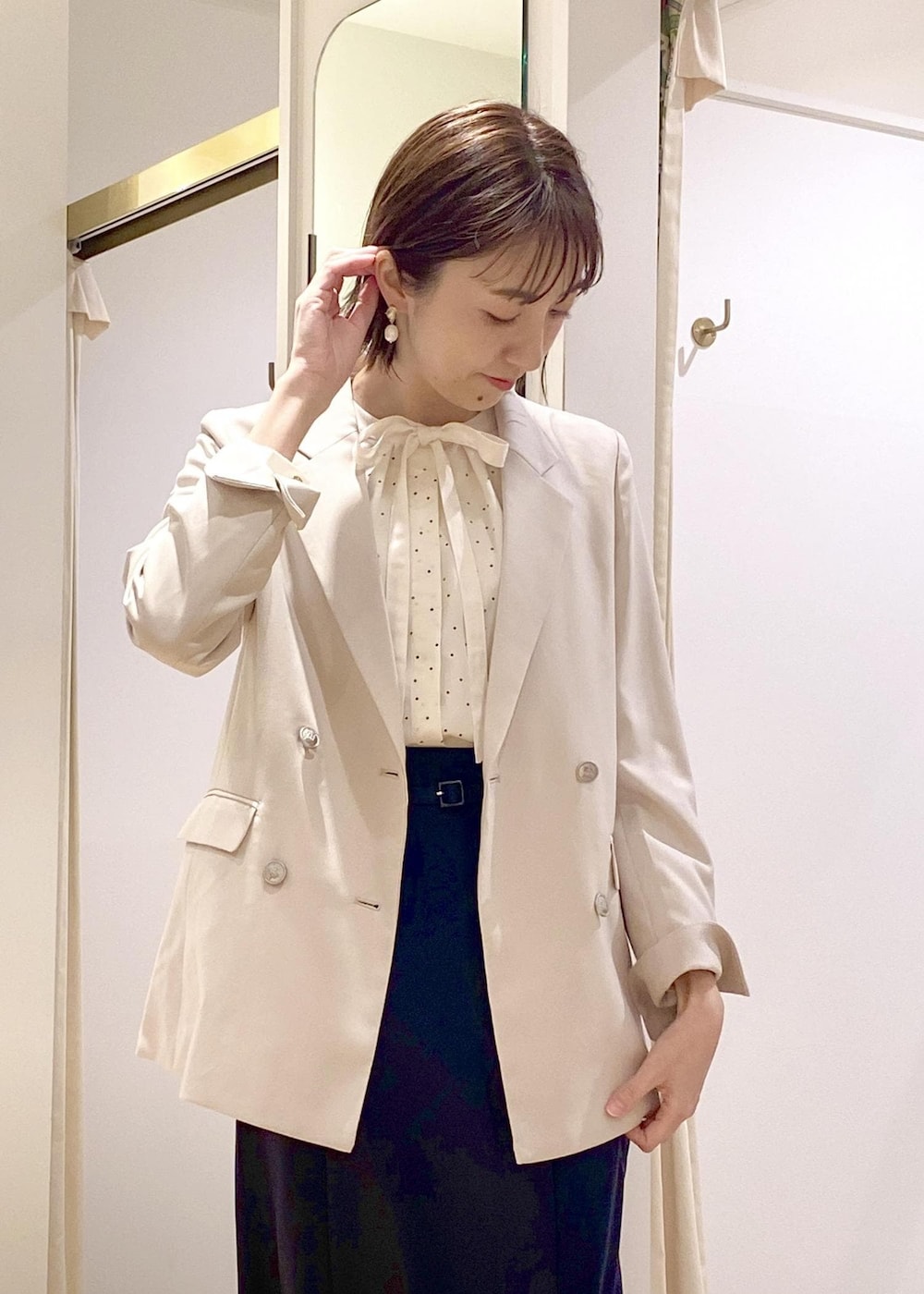 ベージュ系のトートバッグ、ホワイト系のパンプス、ホワイト系のシャツ/ブラウスを着用したレディースの春コーディネートの4枚目の写真