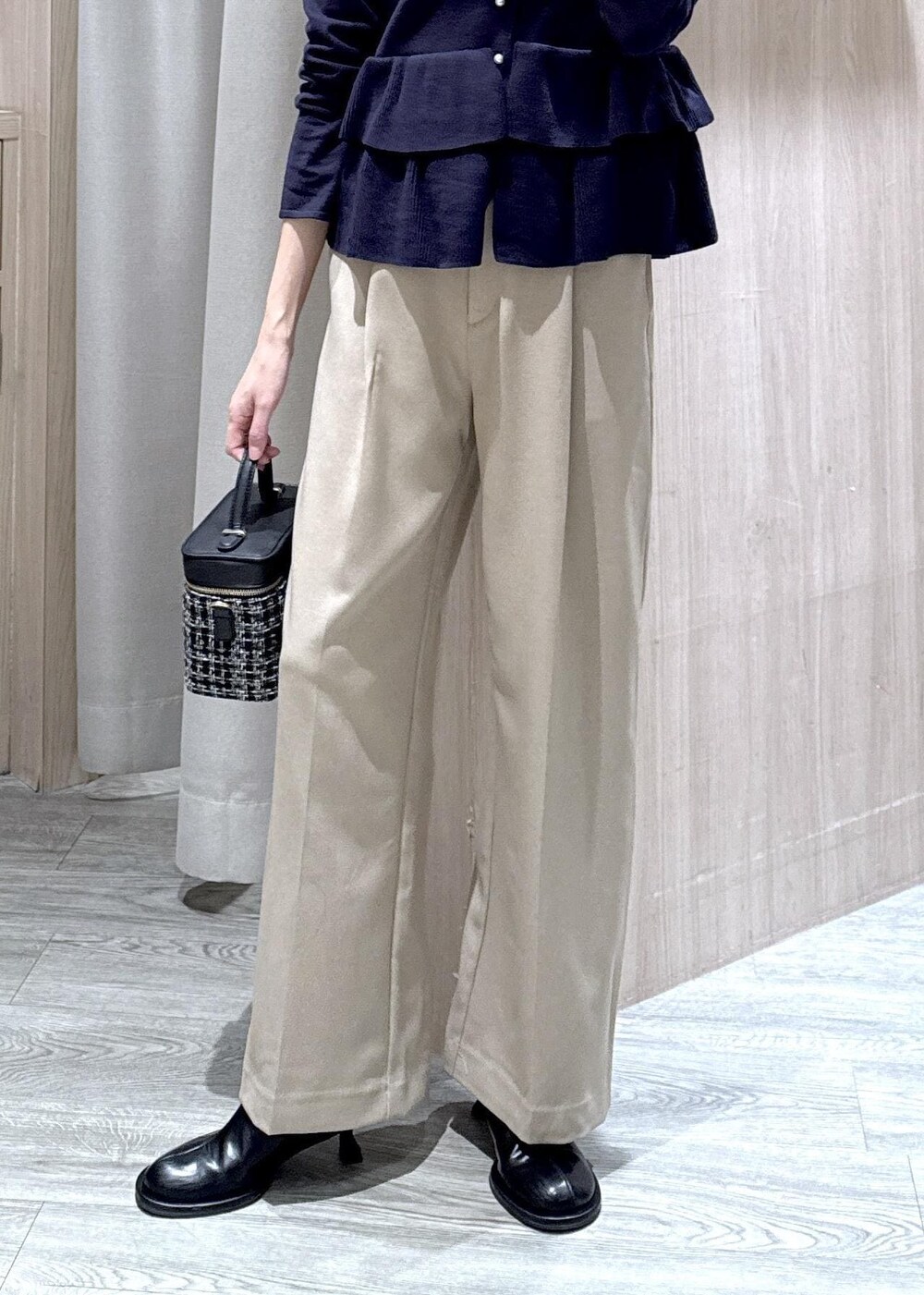 ベージュ系のスラックス、その他のハンドバッグ、ブルー系のカーディガン/ボレロを着用したレディースの冬コーディネートの6枚目の写真