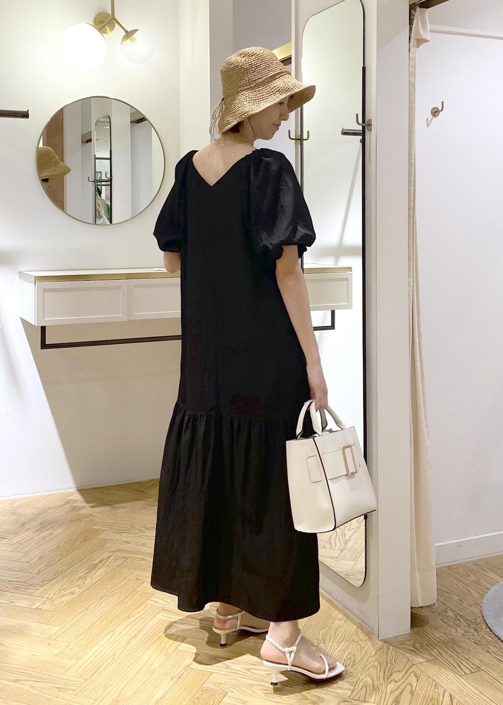 ブラック系のキャミソール、ホワイト系のサンダル、ホワイト系のハンドバッグを着用したレディースの春コーディネートの2枚目の写真