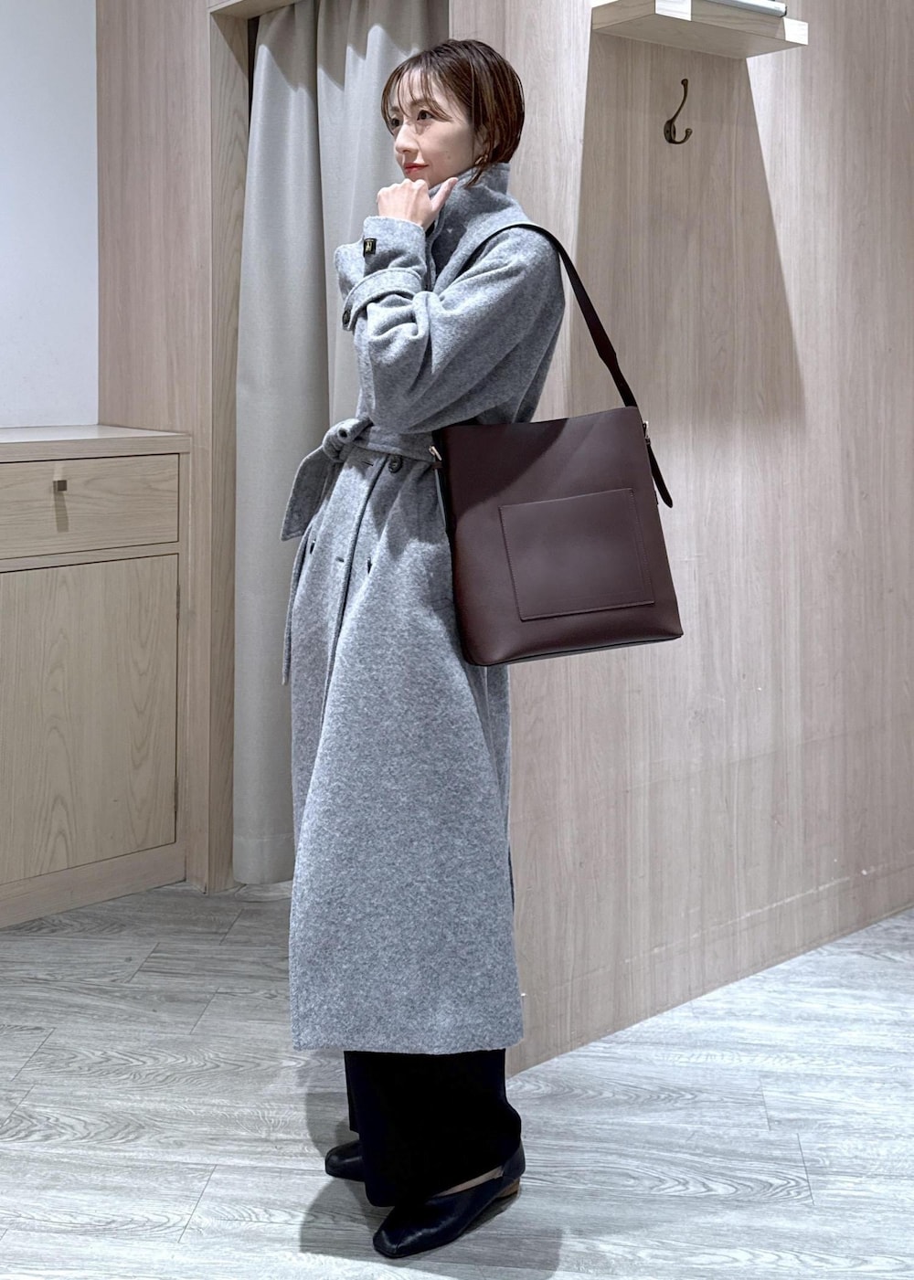 ホワイト系のニット/セーター、グレー系のその他アウター、ブラック系のスラックスを着用したレディースの冬コーディネートの2枚目の写真