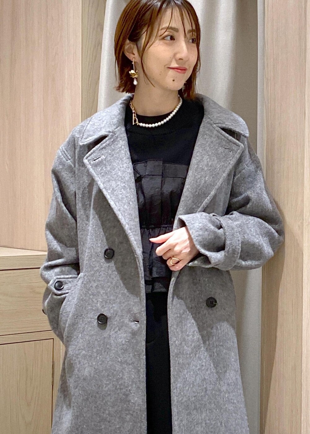 シルバー系のパンプス、ブラック系のスラックス、ブラック系のニット/セーターを着用したレディースの冬コーディネートの6枚目の写真