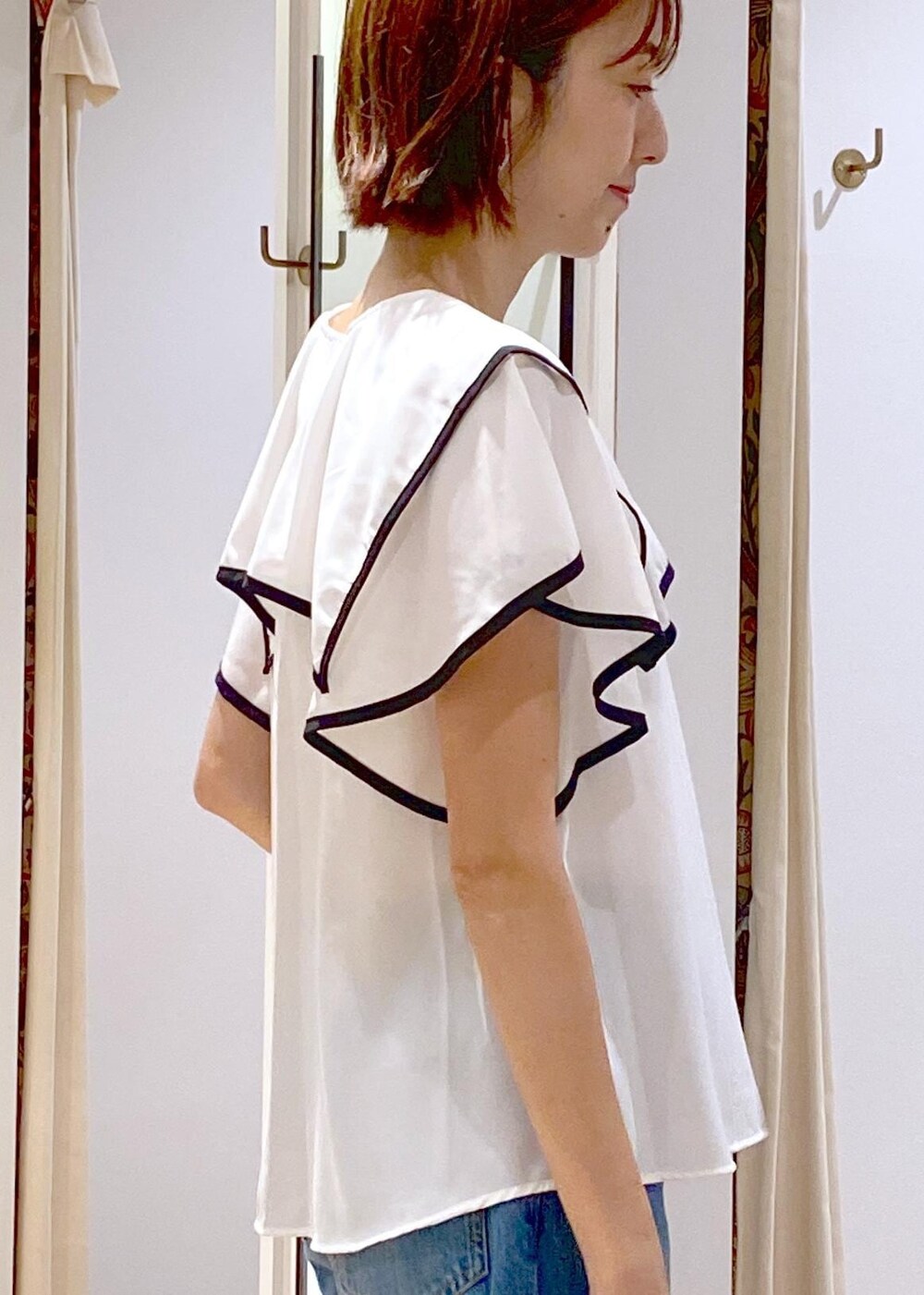 ブラック系のサンダル、ホワイト系のキャミソール、ブルー系のデニムパンツを着用したレディースの夏コーディネートの6枚目の写真