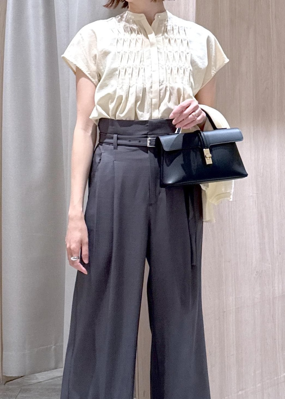 ブラック系のショルダーバッグ、ブラック系のパンプス、ホワイト系のカーディガン/ボレロを着用したレディースの夏コーディネートの5枚目の写真