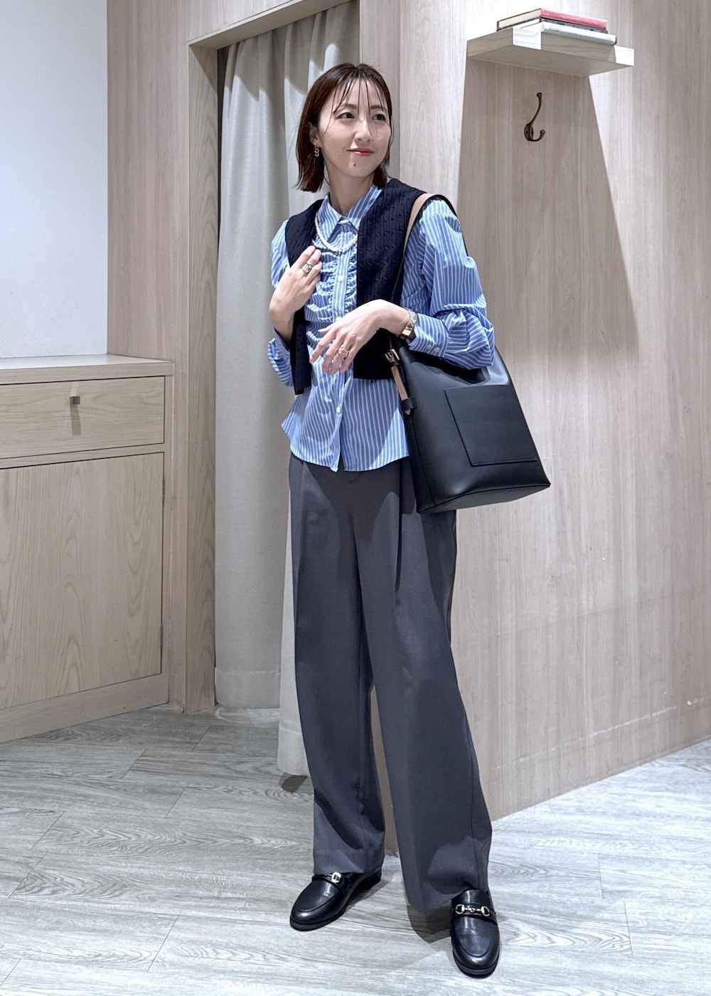 ブラック系のトートバッグ、ブルー系のカーディガン/ボレロ、グレー系のその他パンツを着用したレディースの冬コーディネートの3枚目の写真