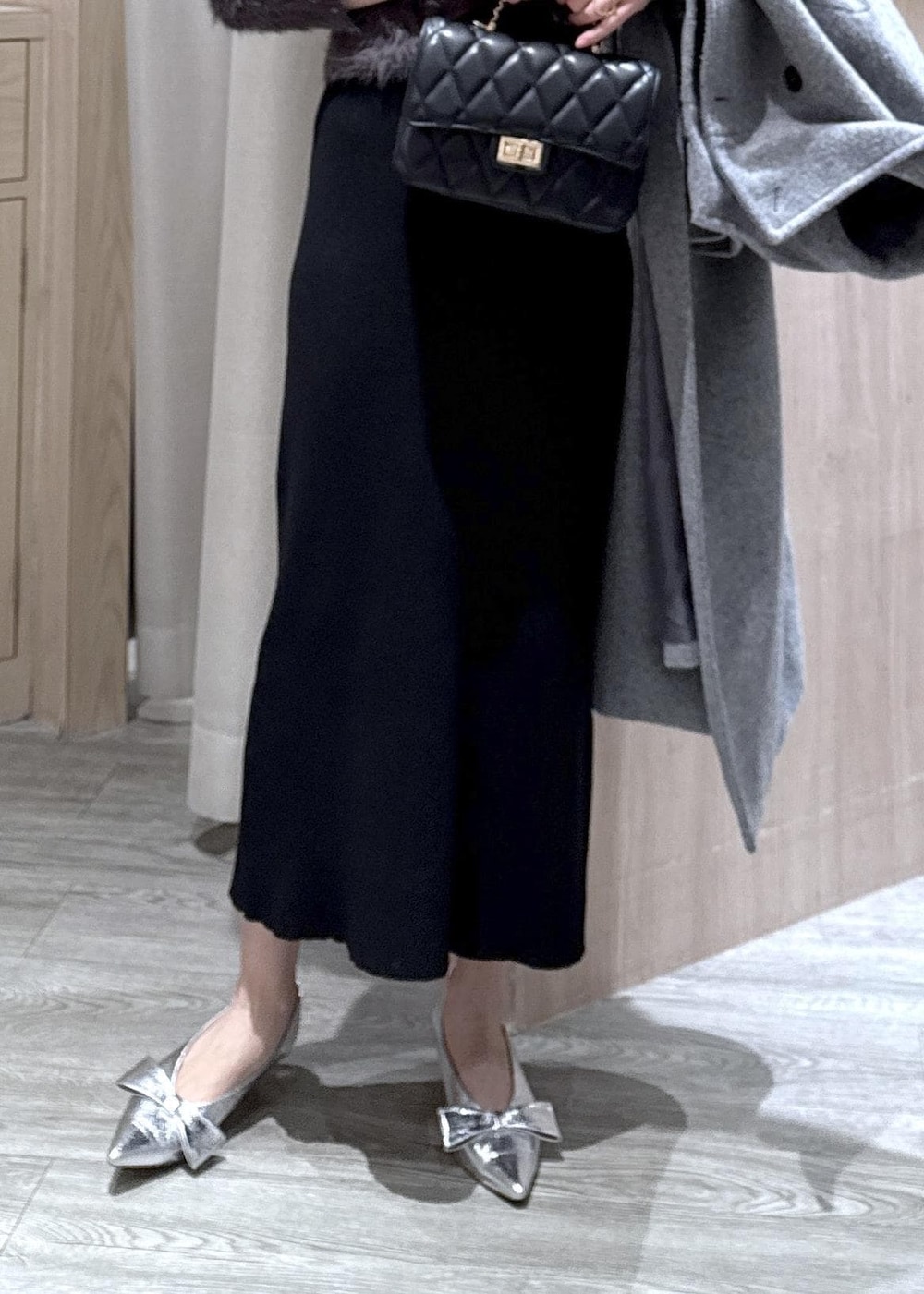 シルバー系のパンプス、グレー系のその他アウター、グレー系のワンピースを着用したレディースの冬コーディネートの6枚目の写真