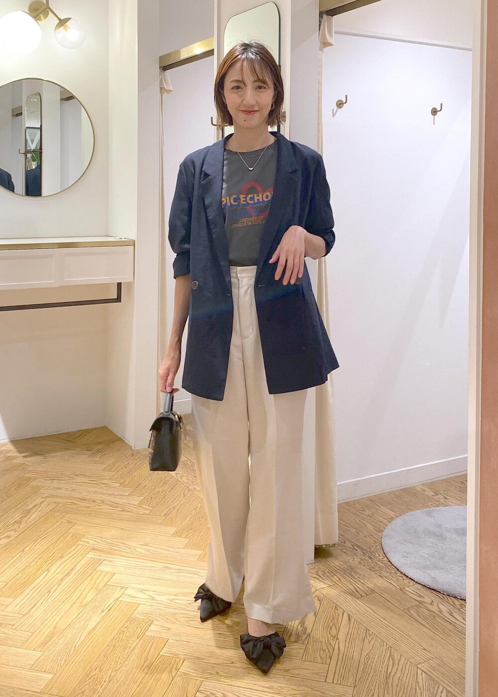 ブルー系のテーラードジャケット、ホワイト系のスラックス、その他のショルダーバッグを着用したレディースの夏コーディネートの2枚目の写真