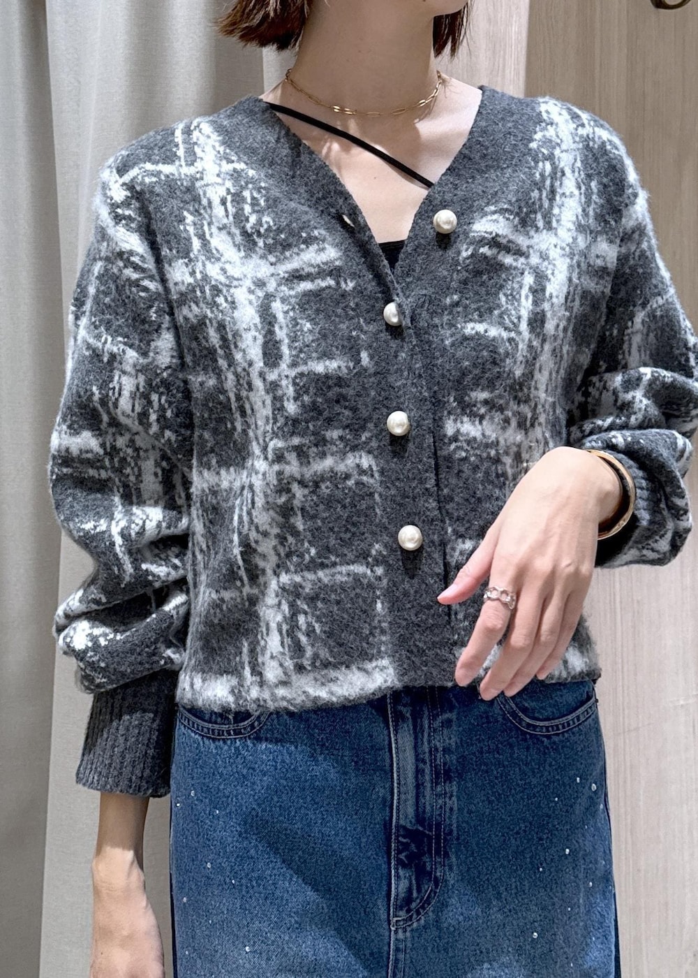 ブルー系のデニムパンツ、イエロー系のハンドバッグ、グレー系のカーディガン/ボレロを着用したレディースの冬コーディネートの6枚目の写真