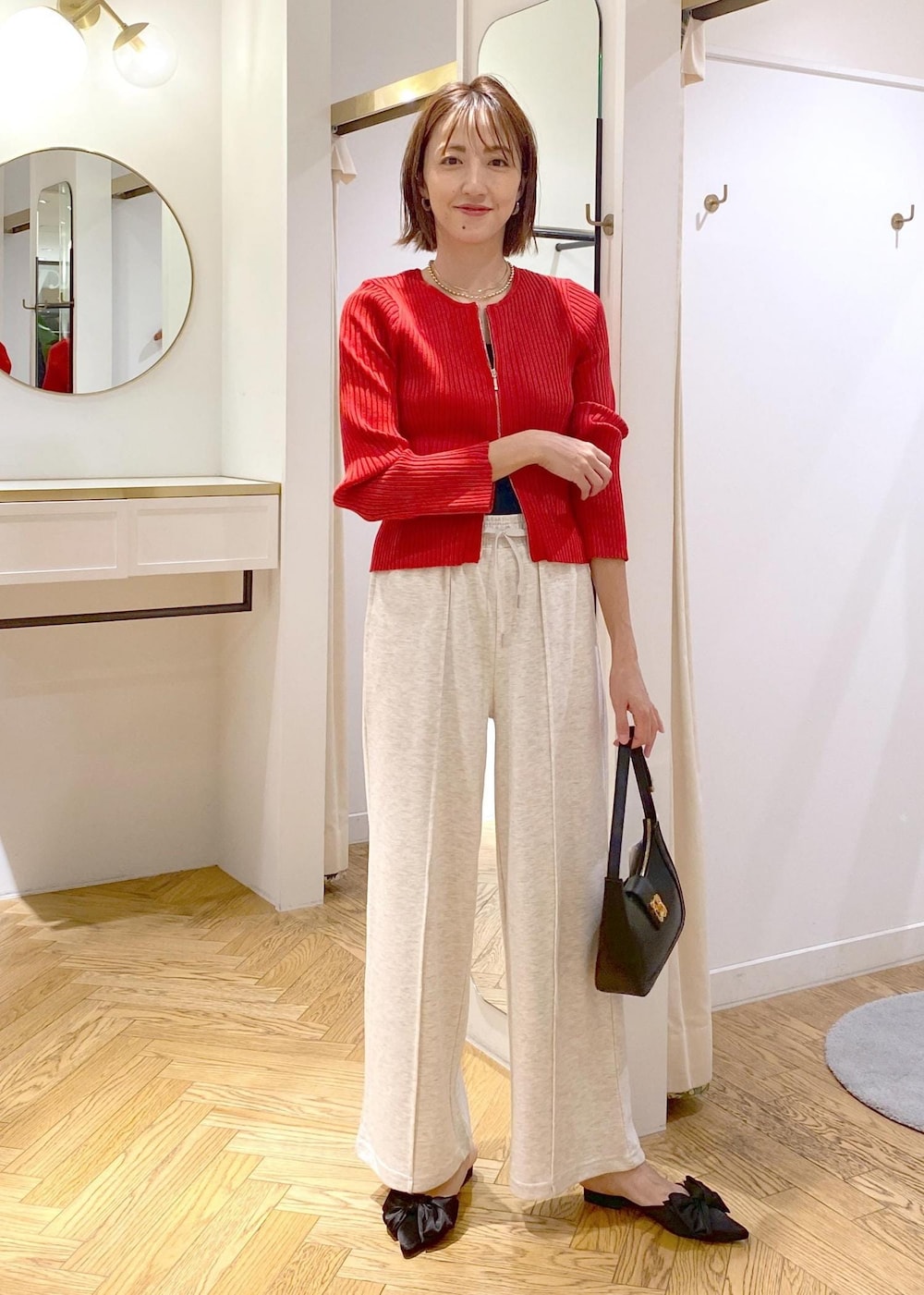 ブラック系のキャミソール、ブラック系のハンドバッグ、ホワイト系のその他パンツを着用したレディースの秋コーディネートの4枚目の写真