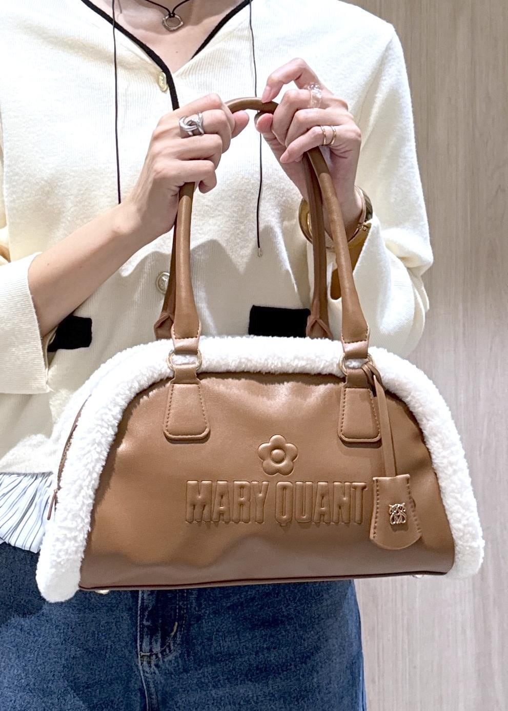 シルバー系のパンプス、ブルー系のデニムパンツ、イエロー系のボストンバッグを着用したレディースの秋コーディネートの6枚目の写真