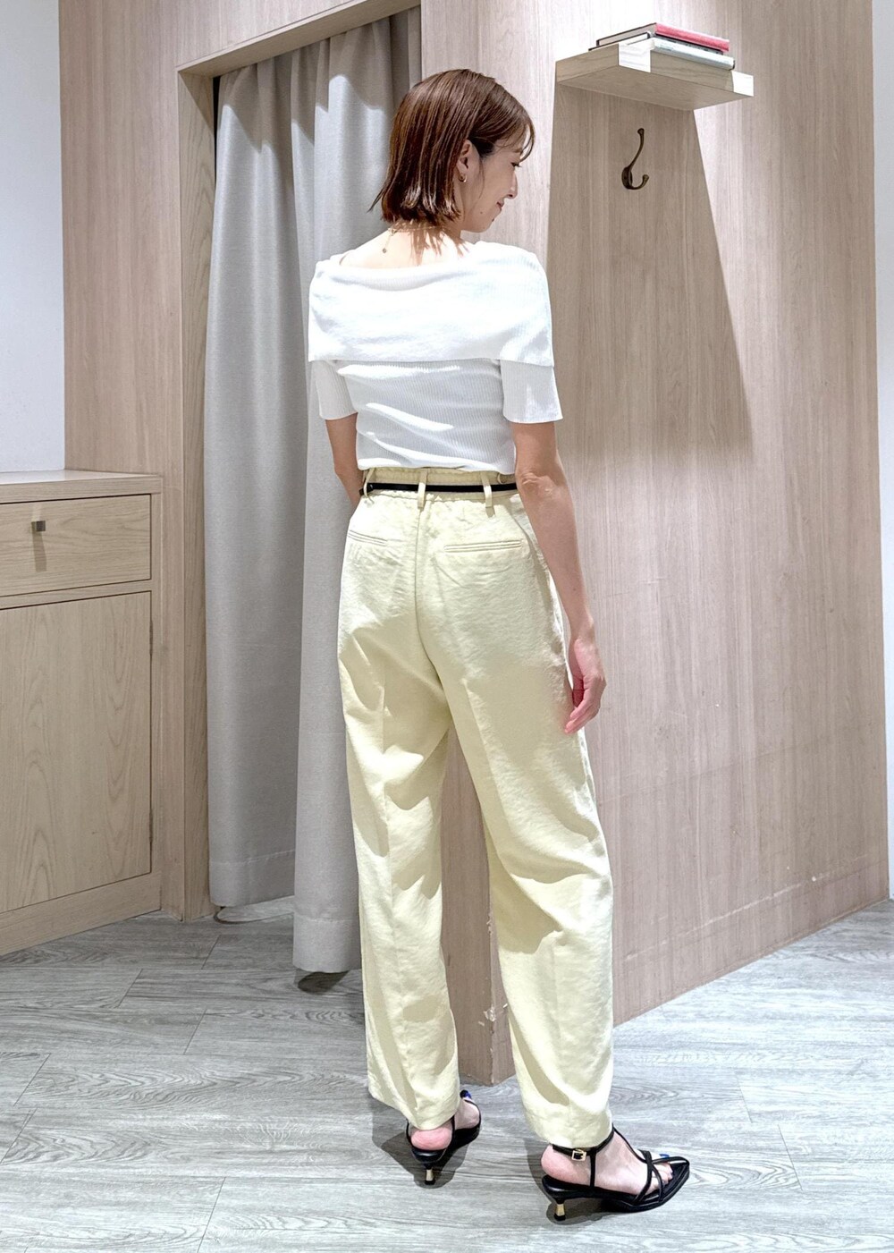 ブルー系のハンドバッグ、ブラック系のサンダル、イエロー系のスラックスを着用したレディースの夏コーディネートの4枚目の写真