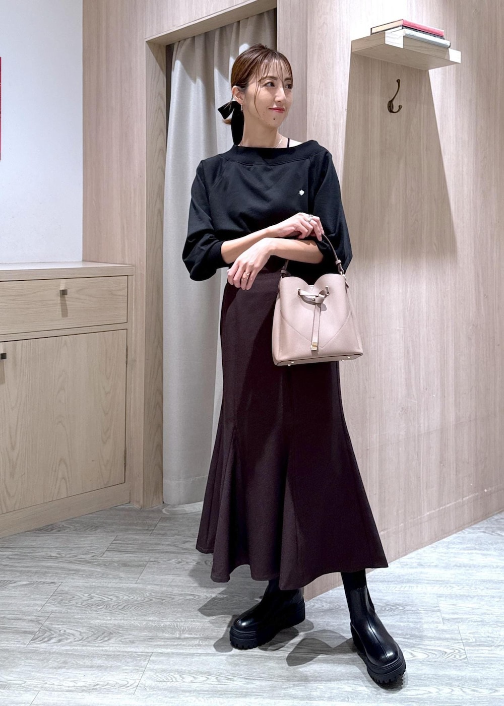 ブラック系のキャミソール、ブラウン系のスカート、ブラック系のブーツを着用したレディースの秋コーディネートの2枚目の写真