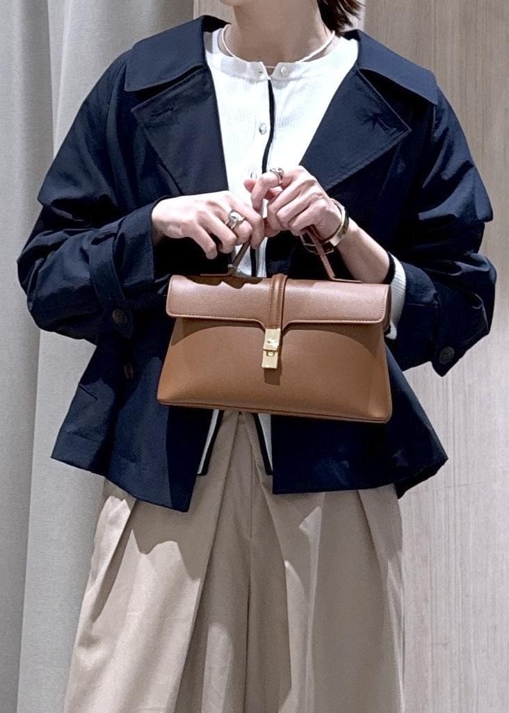 イエロー系のショルダーバッグ、ホワイト系のカーディガン/ボレロ、ベージュ系のその他パンツを着用したレディースの春コーディネートの6枚目の写真