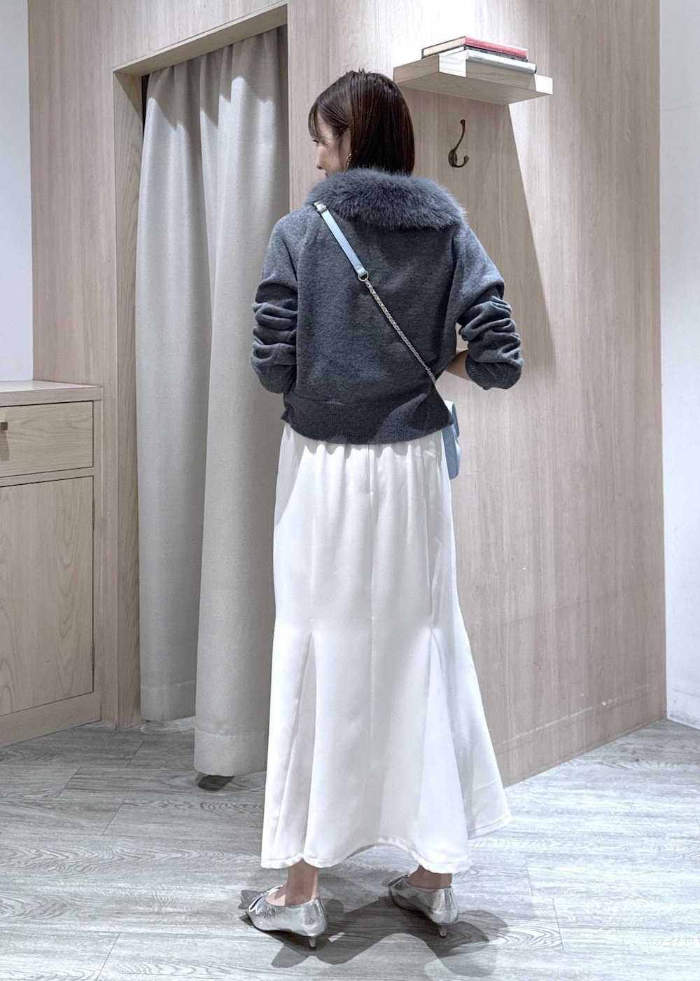 シルバー系のパンプス、ホワイト系のキャミソール、ホワイト系のスカートを着用したレディースの冬コーディネートの9枚目の写真