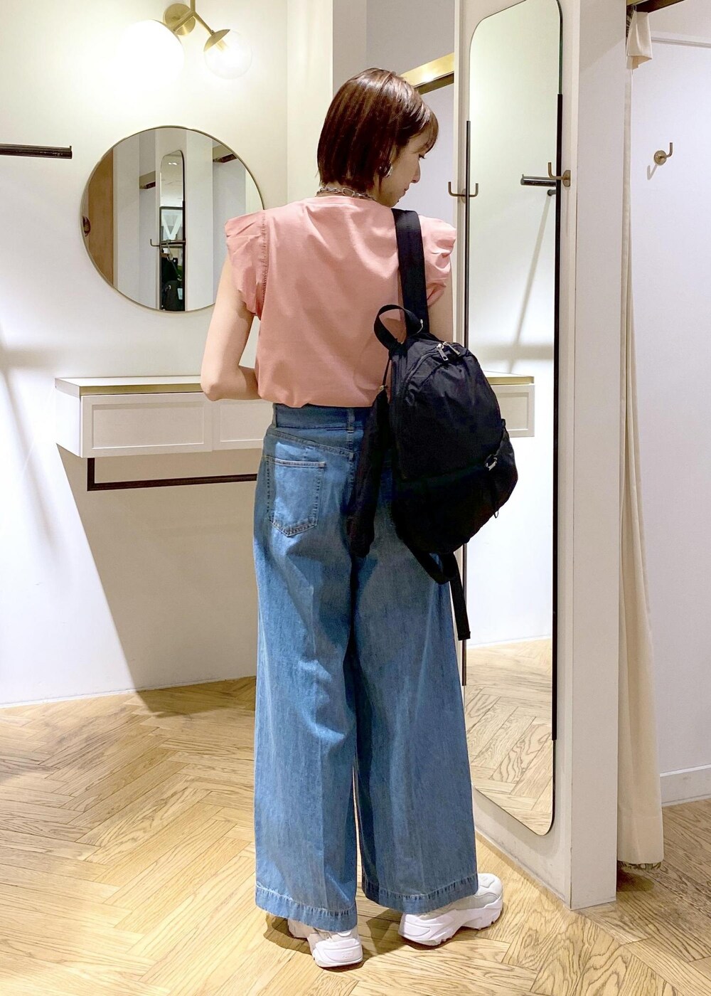 グレー系のスニーカー、ブラック系のバックパック/リュック、ピンク系のTシャツ/カットソーを着用したレディースの春コーディネートの5枚目の写真