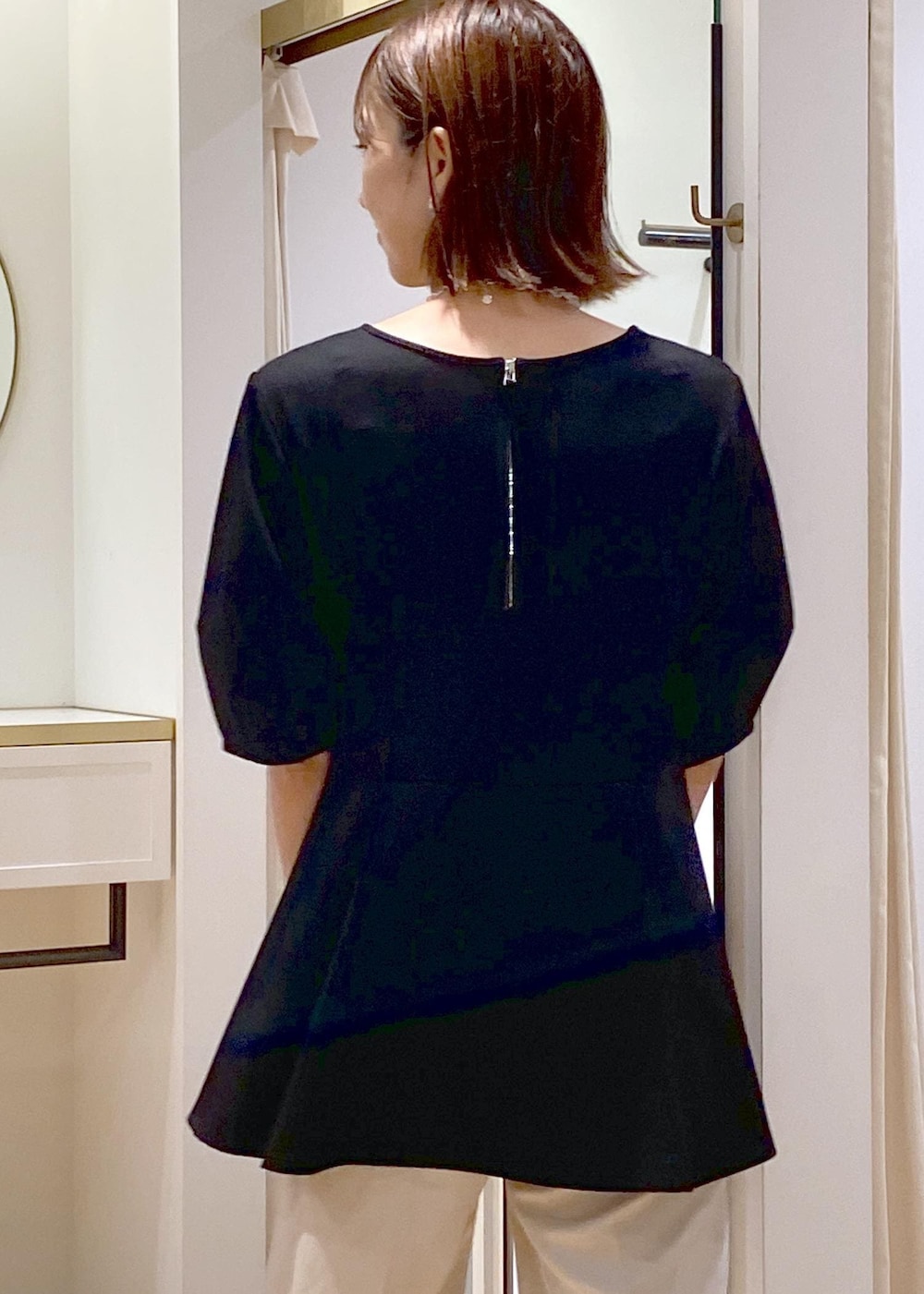 ホワイト系のショルダーバッグ、ホワイト系のスラックス、ブラック系のバレエシューズを着用したレディースの秋コーディネートの8枚目の写真