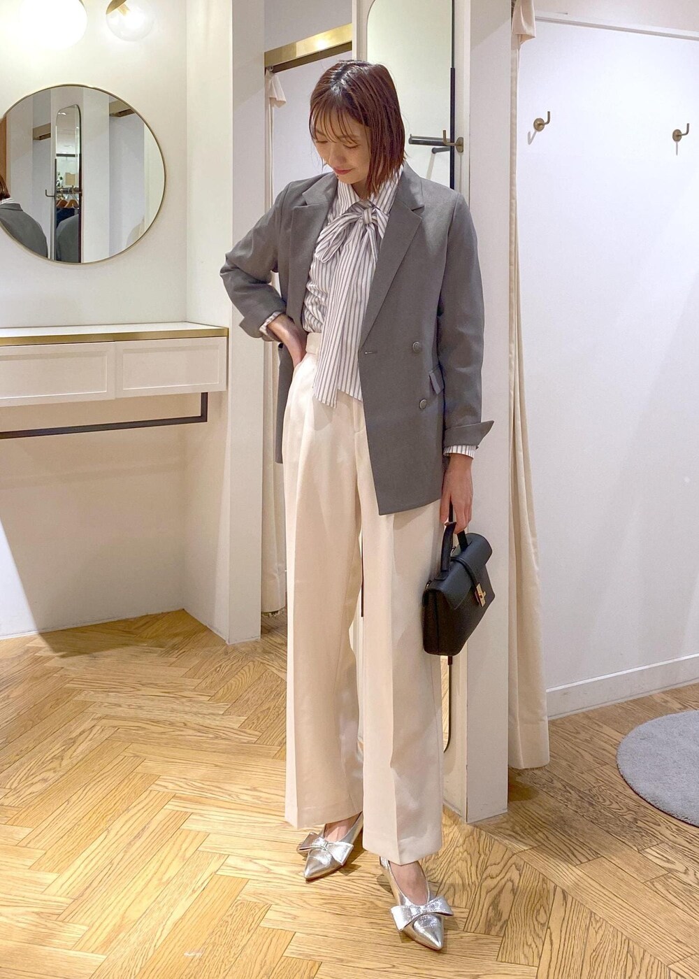 シルバー系のパンプス、ホワイト系のシャツ/ブラウス、ホワイト系のスラックスを着用したレディースの冬コーディネートの4枚目の写真