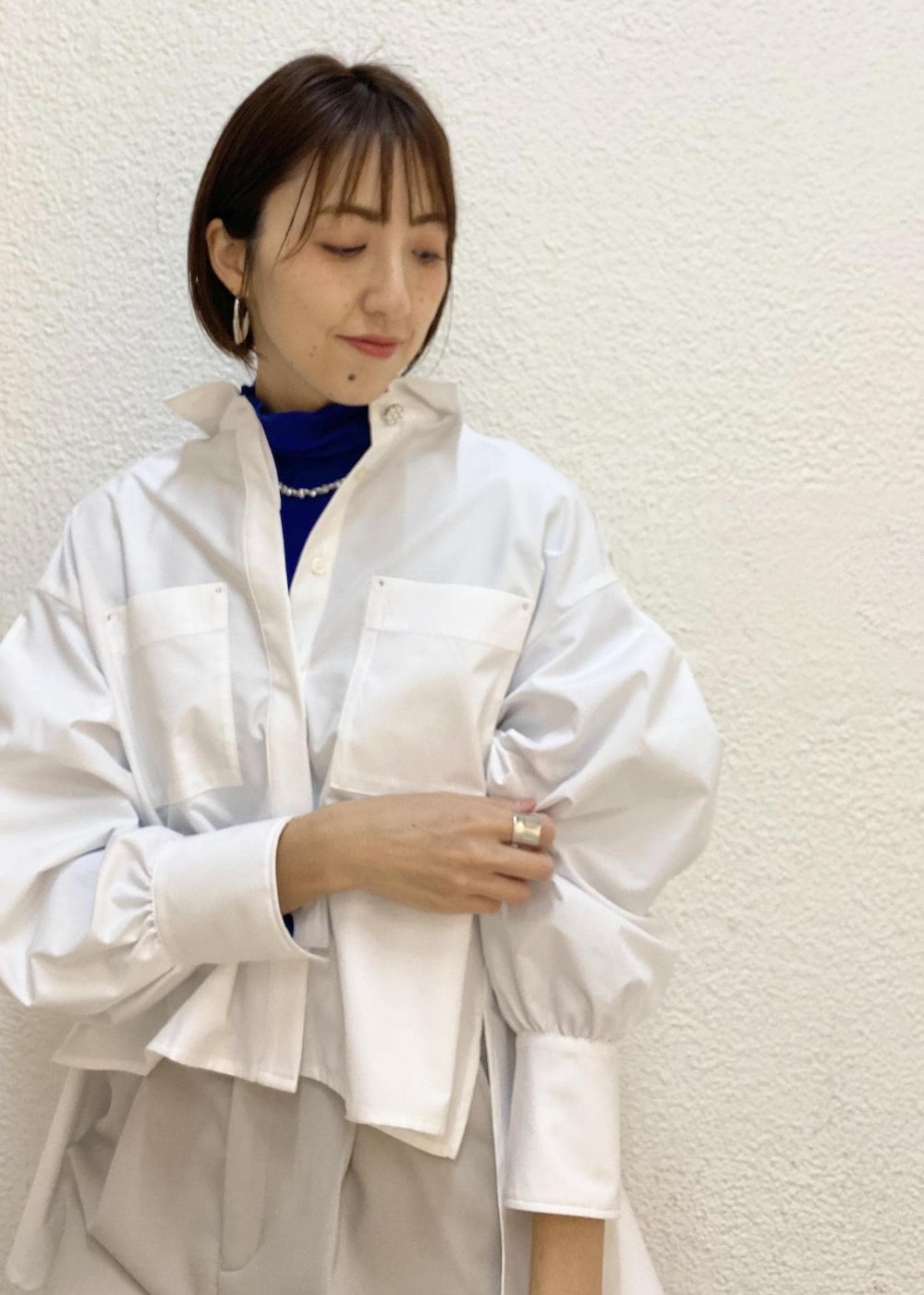 ブルー系のニット/セーター、グレー系のスラックス、ブラック系のハンドバッグを着用したレディースの冬コーディネートの3枚目の写真