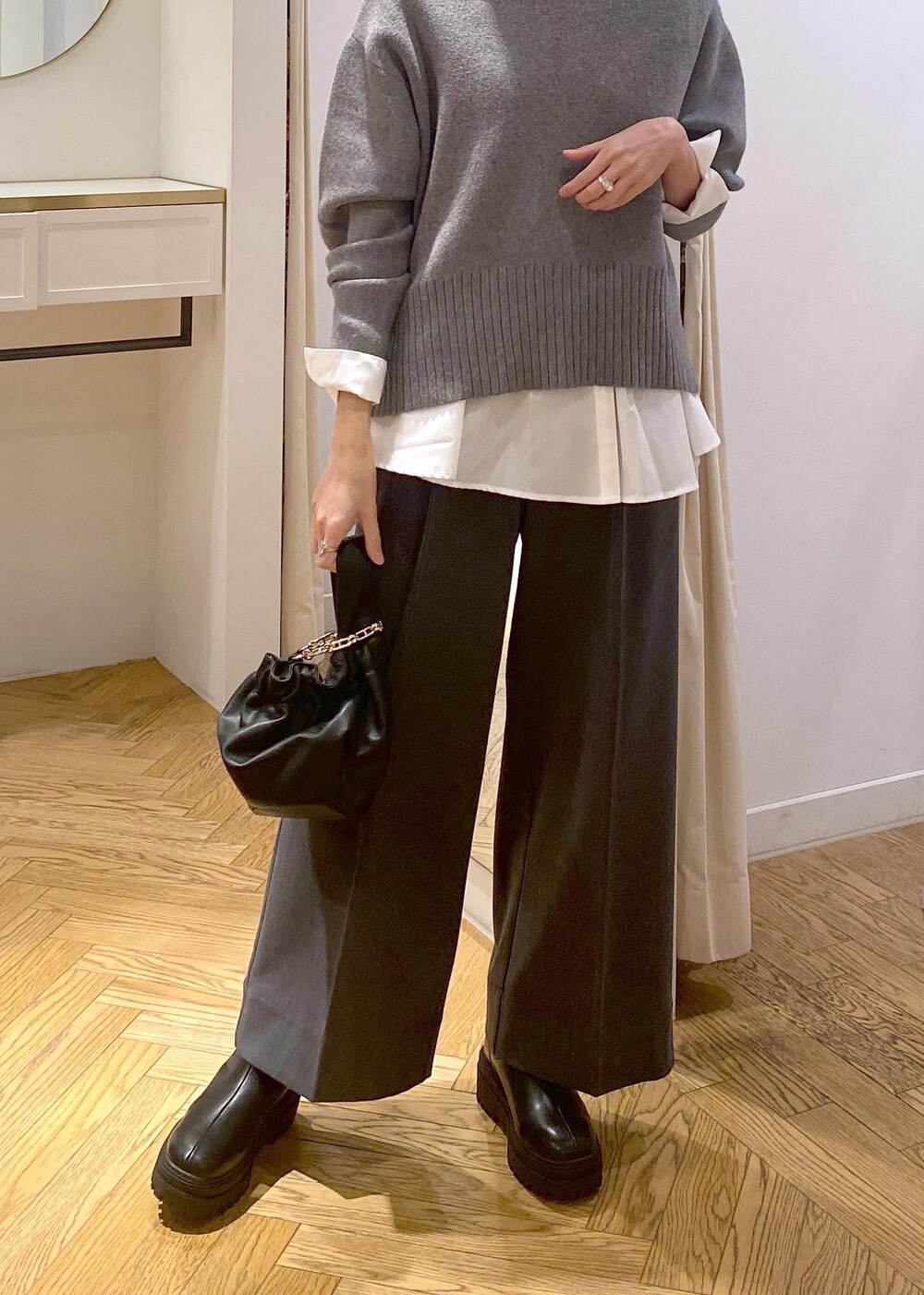 ブラック系のブーツ、ホワイト系のシャツ/ブラウス、グレー系のニット/セーターを着用したレディースの冬コーディネートの5枚目の写真