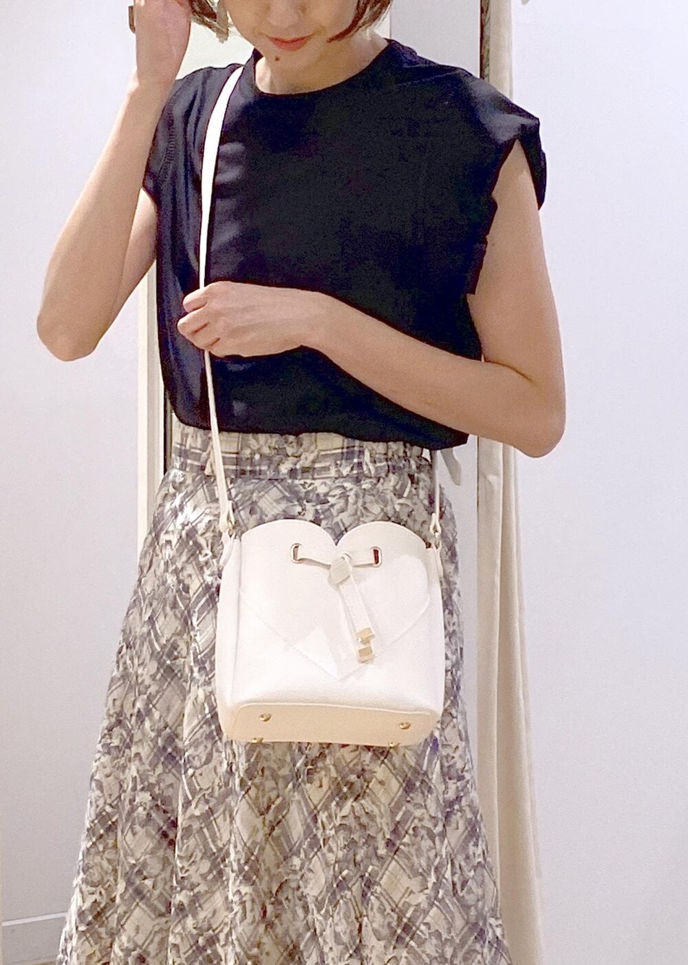 ブラック系のキャミソール、グリーン系のサンダル、ホワイト系のスカートを着用したレディースの夏コーディネートの8枚目の写真