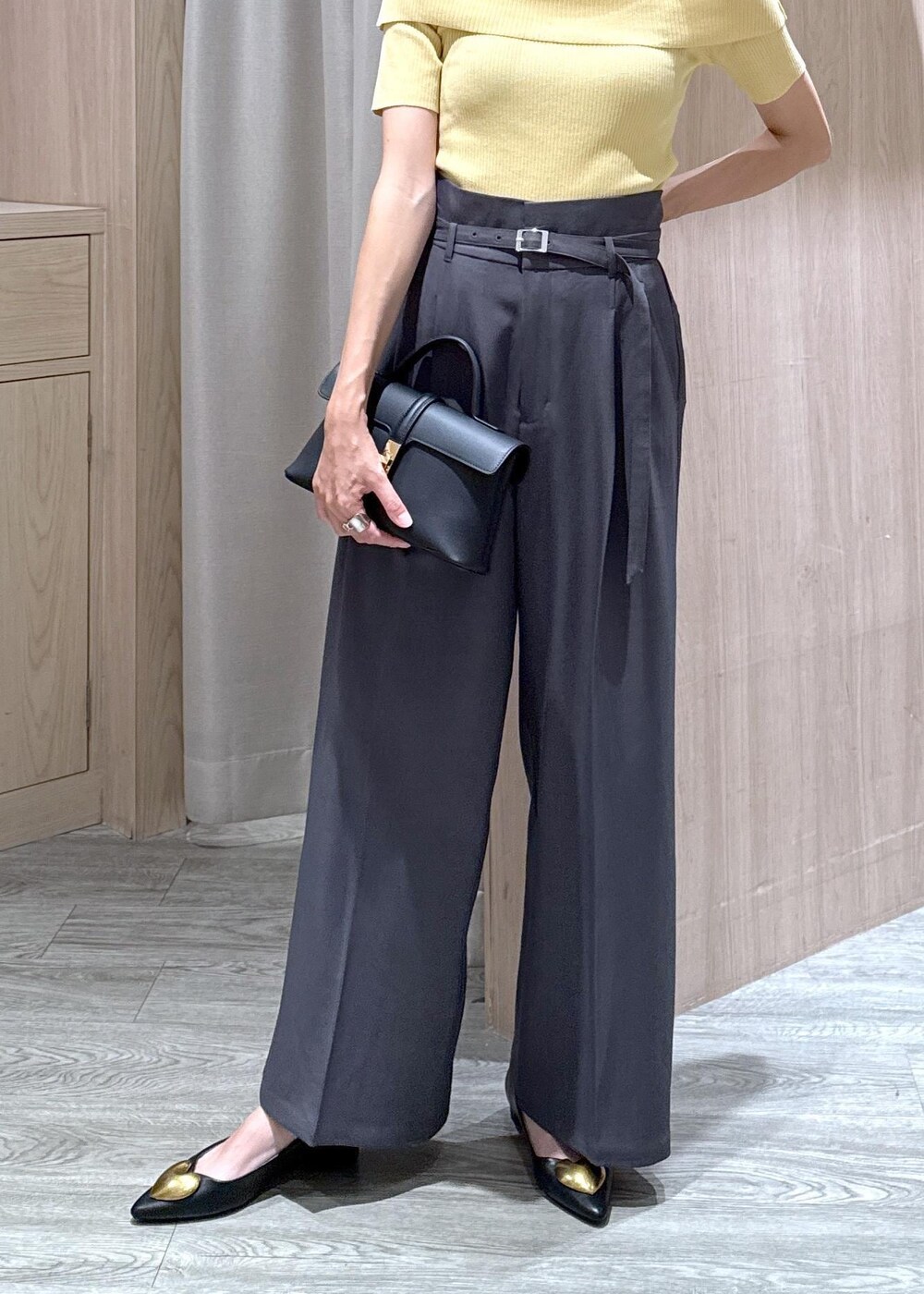 ブラック系のショルダーバッグ、ブラック系のバレエシューズ、イエロー系のニット/セーターを着用したレディースの夏コーディネートの5枚目の写真