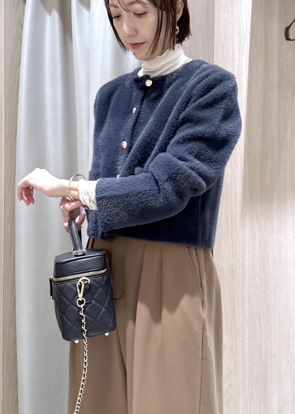 ブルー系のカーディガン/ボレロ、ホワイト系のTシャツ/カットソー、ブラック系のブーツを着用したレディースの冬コーディネートの8枚目の写真