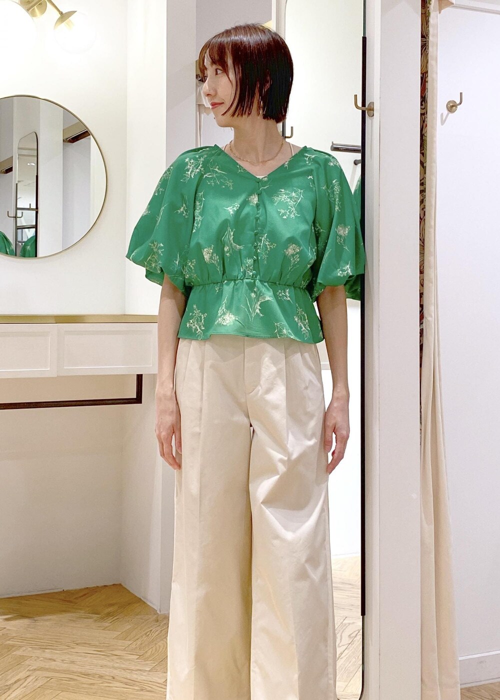 ホワイト系のスラックス、ブラック系のサンダル、ホワイト系のキャミソールを着用したレディースの春コーディネートの3枚目の写真