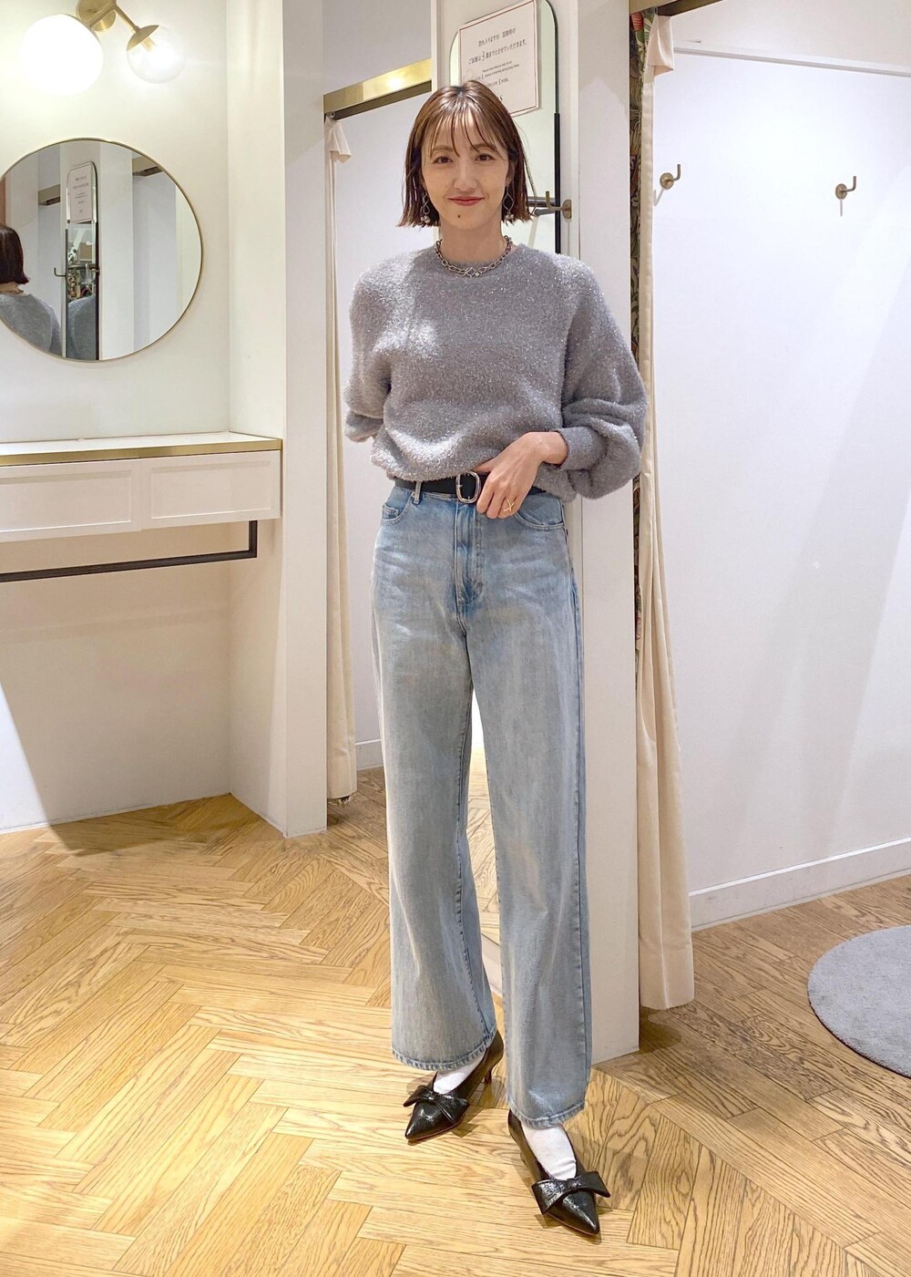 ブラック系のパンプス、グレー系のニット/セーター、ブルー系のデニムパンツを着用したレディースの冬コーディネートの8枚目の写真