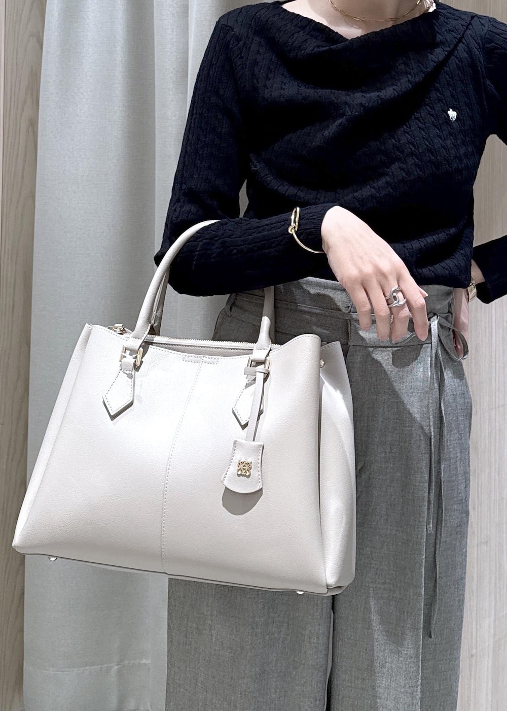 ブラック系のパンプス、グレー系のその他パンツ、ホワイト系のテーラードジャケットを着用したレディースの春コーディネートの9枚目の写真