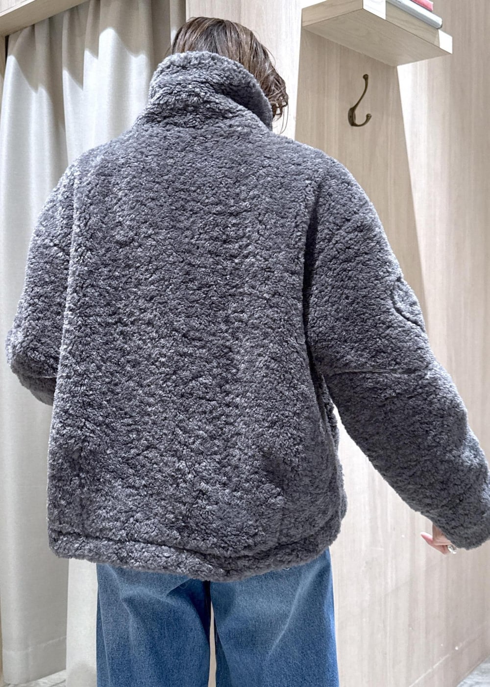 グレー系のブルゾン、グレー系のニット/セーター、ブルー系のデニムパンツを着用したレディースの冬コーディネートの10枚目の写真