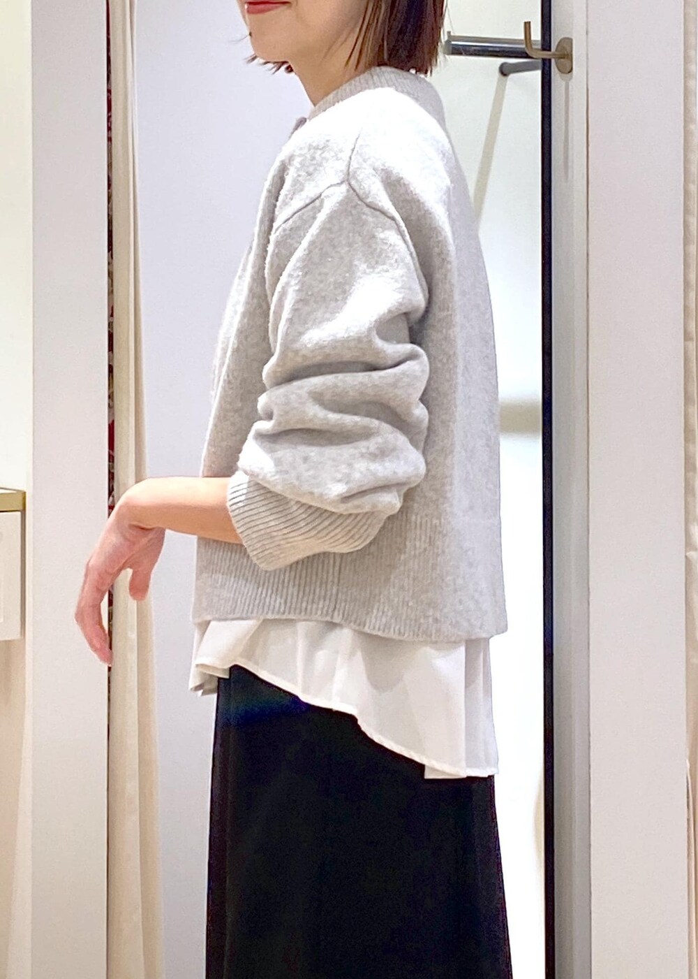 ホワイト系のシャツ/ブラウス、グレー系のカーディガン/ボレロ、ホワイト系のブーツを着用したレディースの冬コーディネートの9枚目の写真