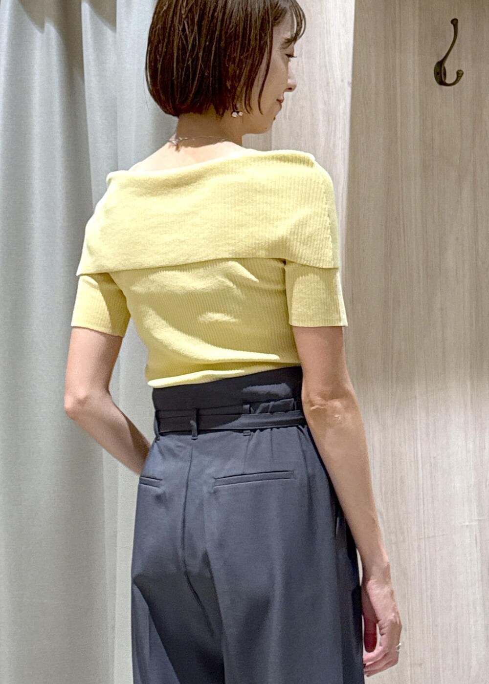 ブラック系のショルダーバッグ、ブラック系のバレエシューズ、イエロー系のニット/セーターを着用したレディースの夏コーディネートの8枚目の写真