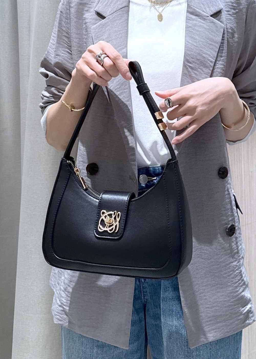 ブラック系のショルダーバッグ、ブラック系のパンプス、ホワイト系のTシャツ/カットソーを着用したレディースの春コーディネートの9枚目の写真