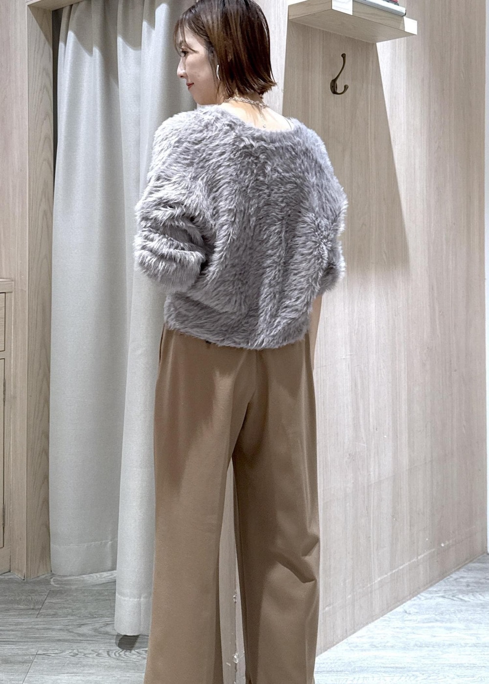 ブラック系のショルダーバッグ、グレー系のカーディガン/ボレロ、ブラック系のブーツを着用したレディースの秋コーディネートの7枚目の写真