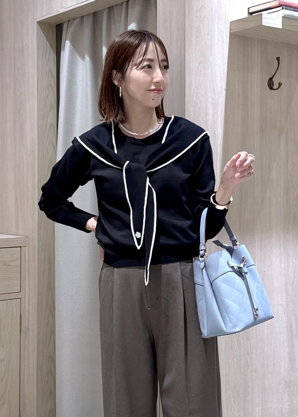 グリーン系のその他パンツ、ブラック系のパンプス、ブルー系のショルダーバッグを着用したレディースの秋コーディネートの3枚目の写真