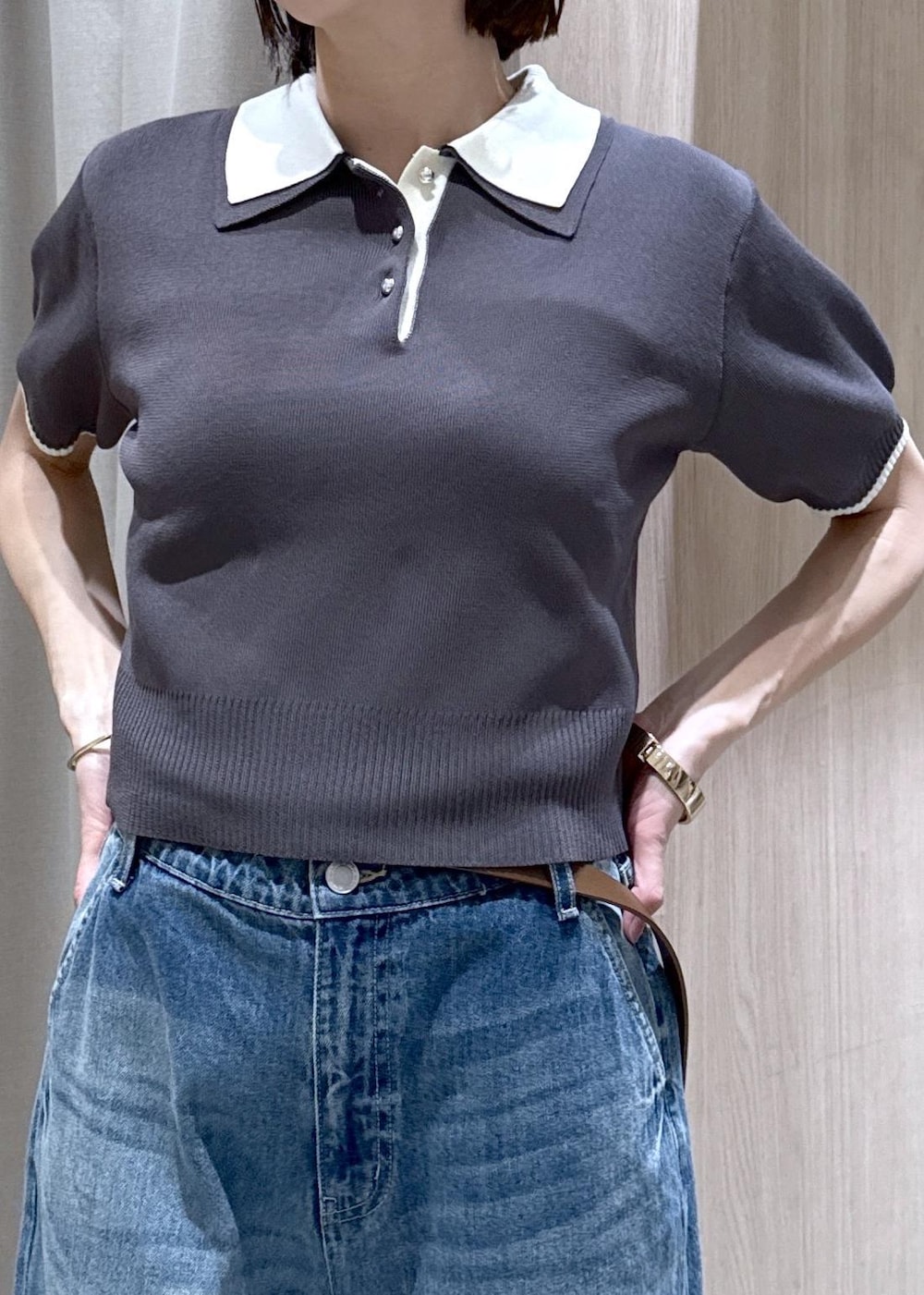 ホワイト系のキャミソール、ブラック系のトートバッグ、ブルー系のデニムパンツを着用したレディースの春コーディネートの6枚目の写真