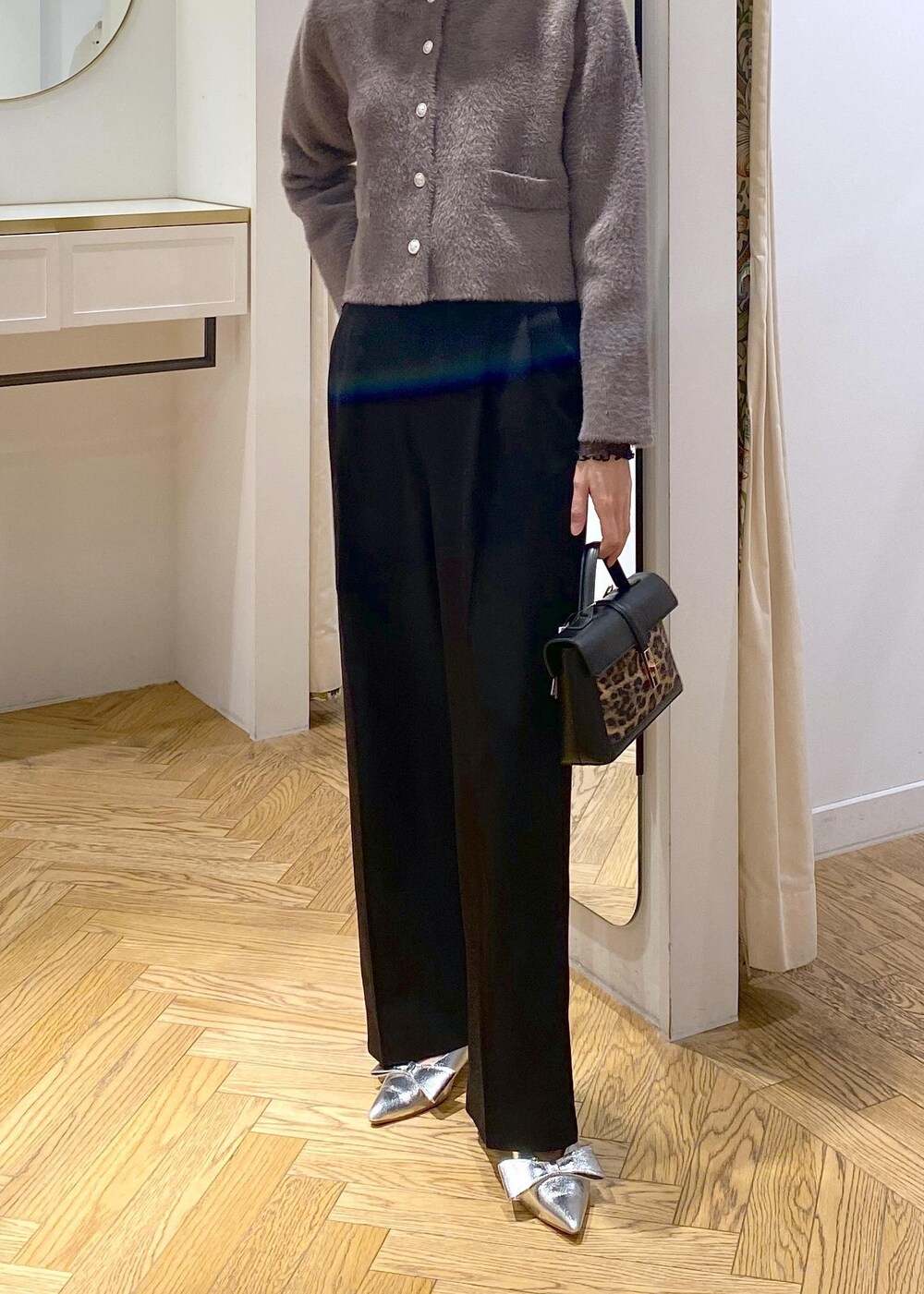 シルバー系のパンプス、ブラウン系のカーディガン/ボレロ、ブラック系のTシャツ/カットソーを着用したレディースの冬コーディネートの5枚目の写真