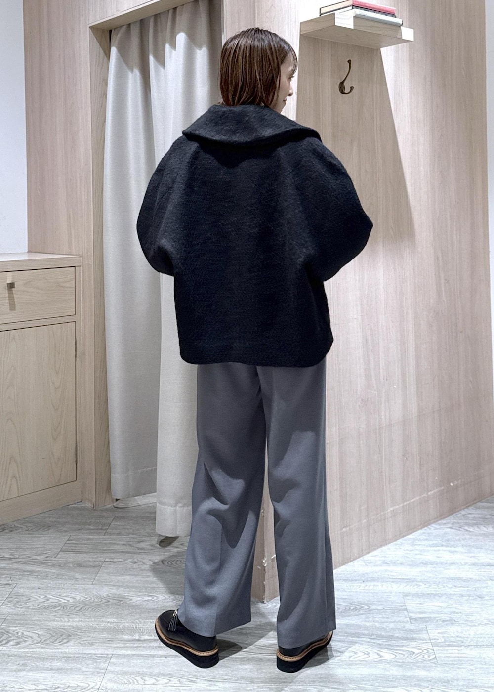 ホワイト系のショルダーバッグ、ブラック系のローファー、ブルー系のカーディガン/ボレロを着用したレディースの冬コーディネートの9枚目の写真