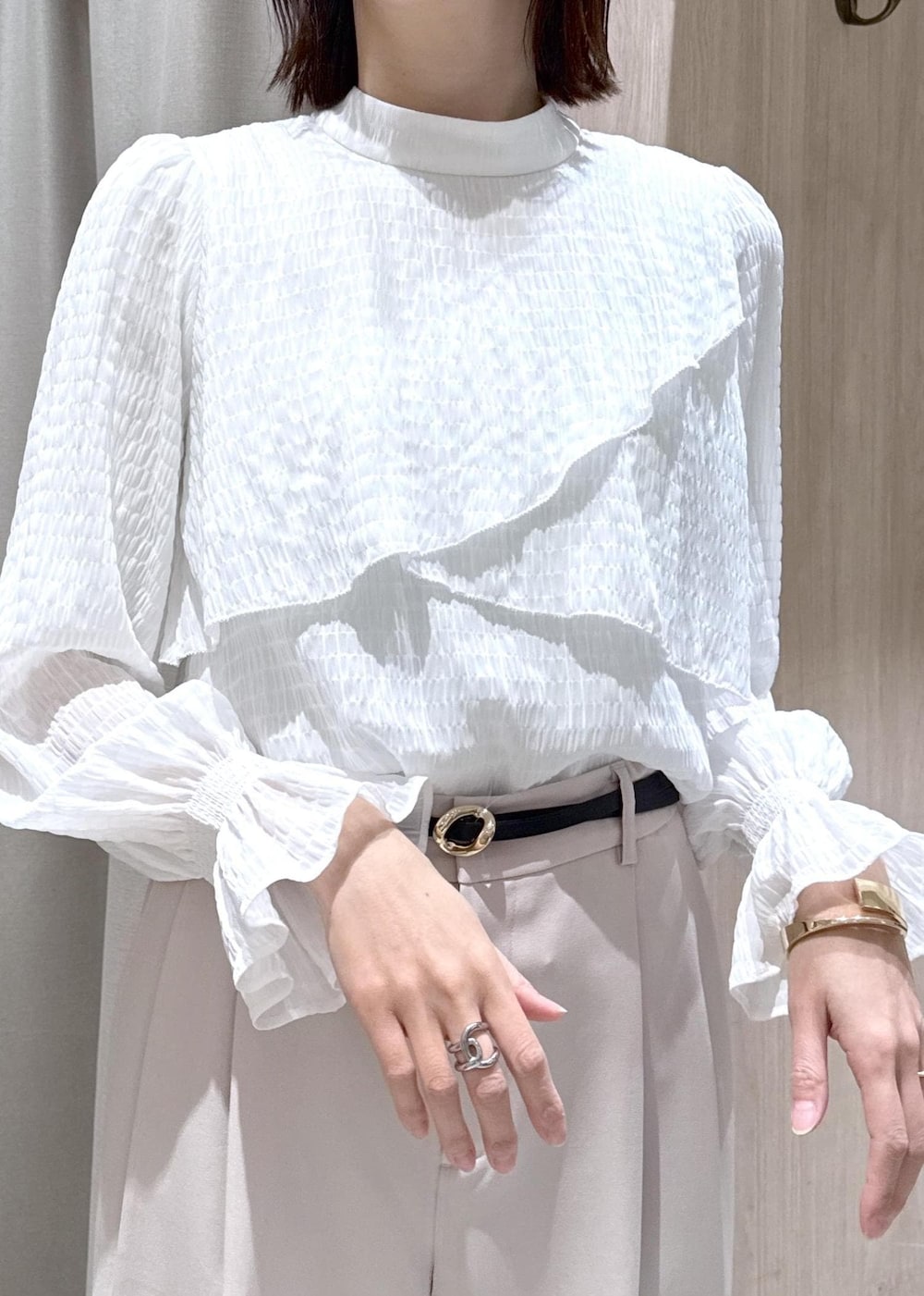 ブラック系のショルダーバッグ、ホワイト系のシャツ/ブラウス、ベージュ系のその他パンツを着用したレディースの冬コーディネートの6枚目の写真