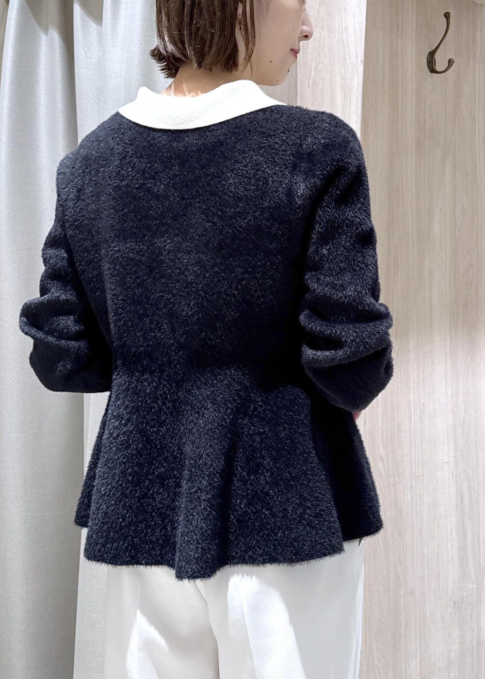 ブラック系のダウンジャケット/コート、ホワイト系のスラックス、ブラック系のニット/セーターを着用したレディースの冬コーディネートの7枚目の写真