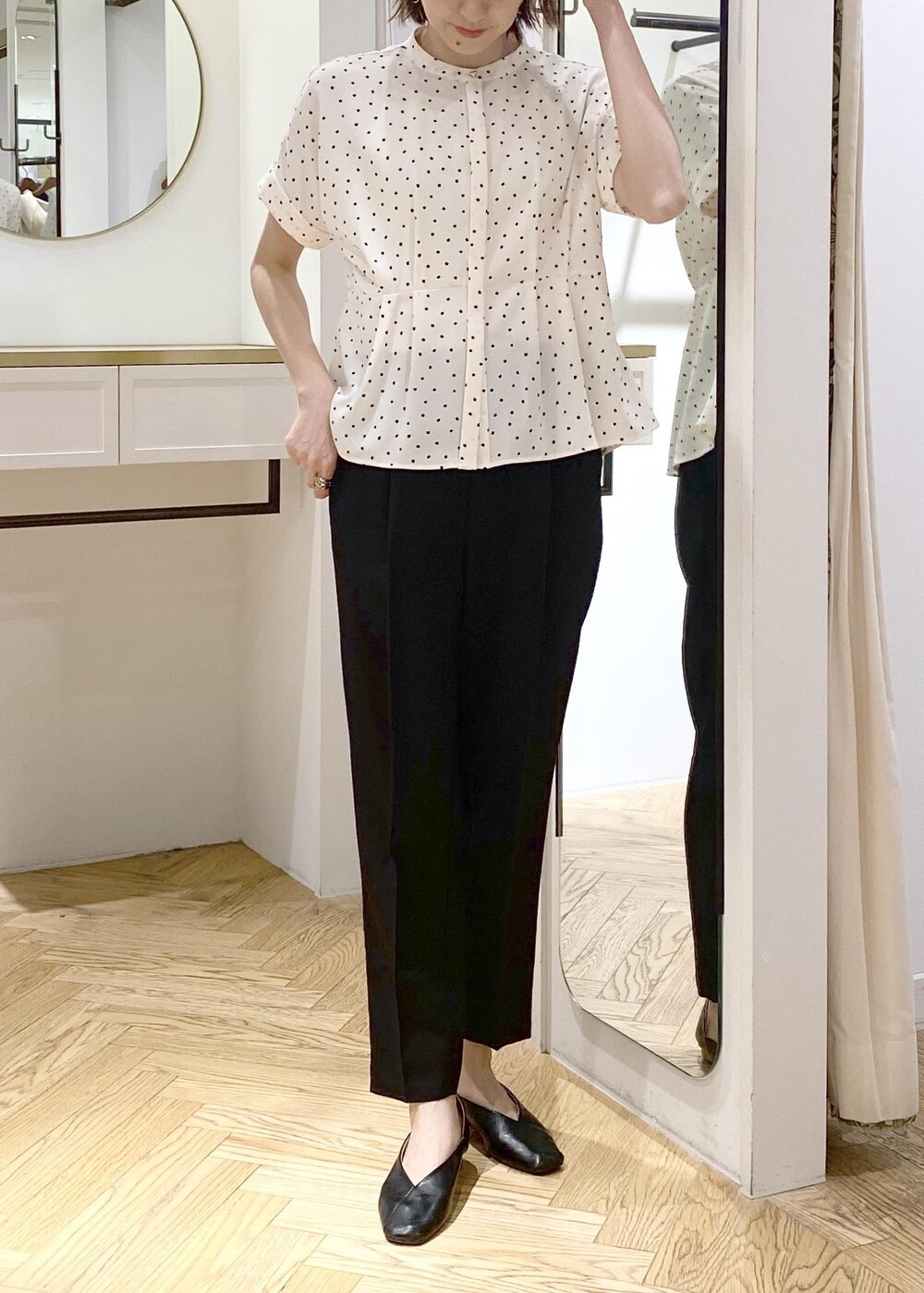 ホワイト系のキャミソール、ブラック系のパンプス、ホワイト系のトートバッグを着用したレディースの春コーディネートの3枚目の写真