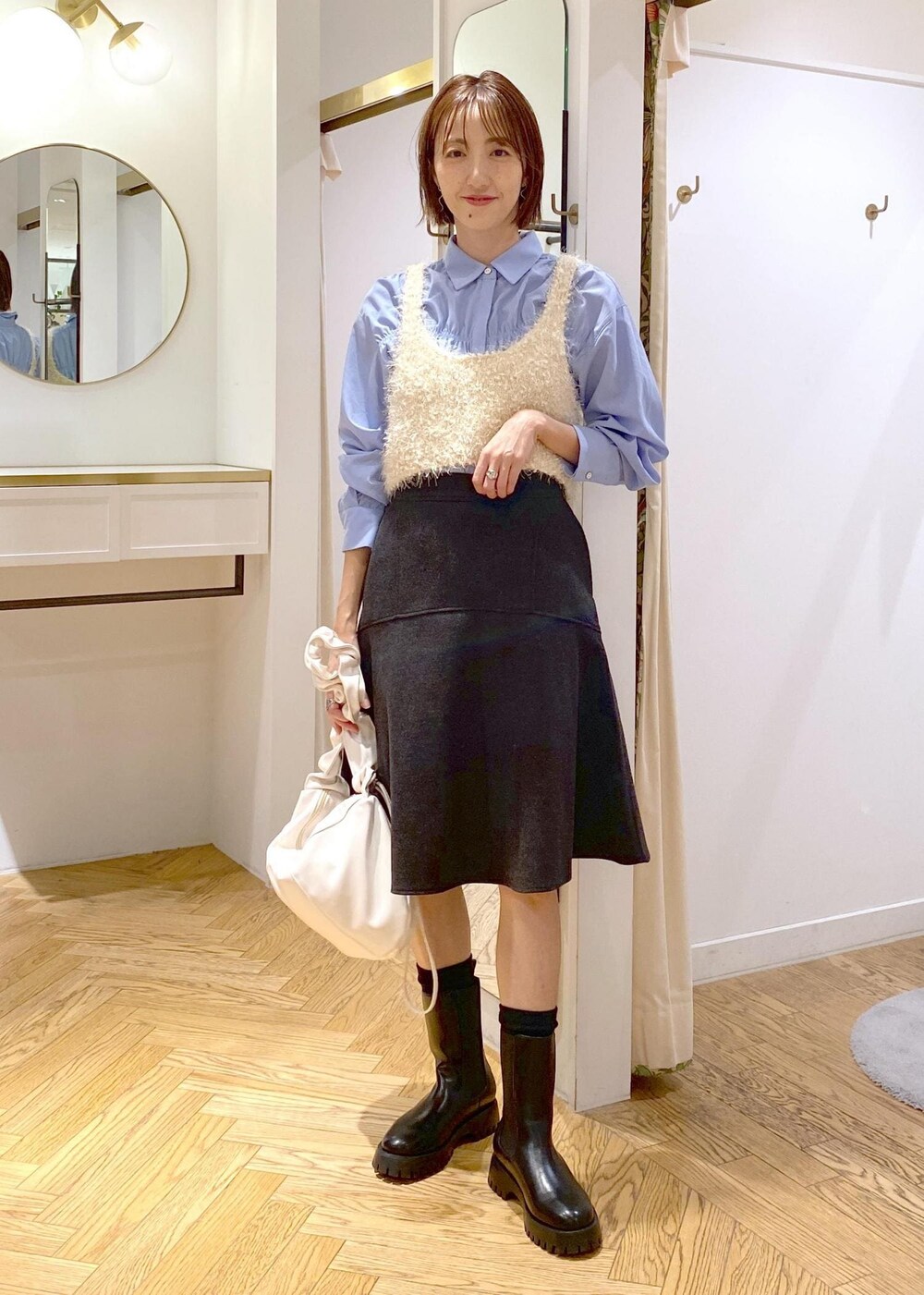 グレー系のスカート、ホワイト系のキャミソール、ブルー系のシャツ/ブラウスを着用したレディースの秋コーディネートの9枚目の写真