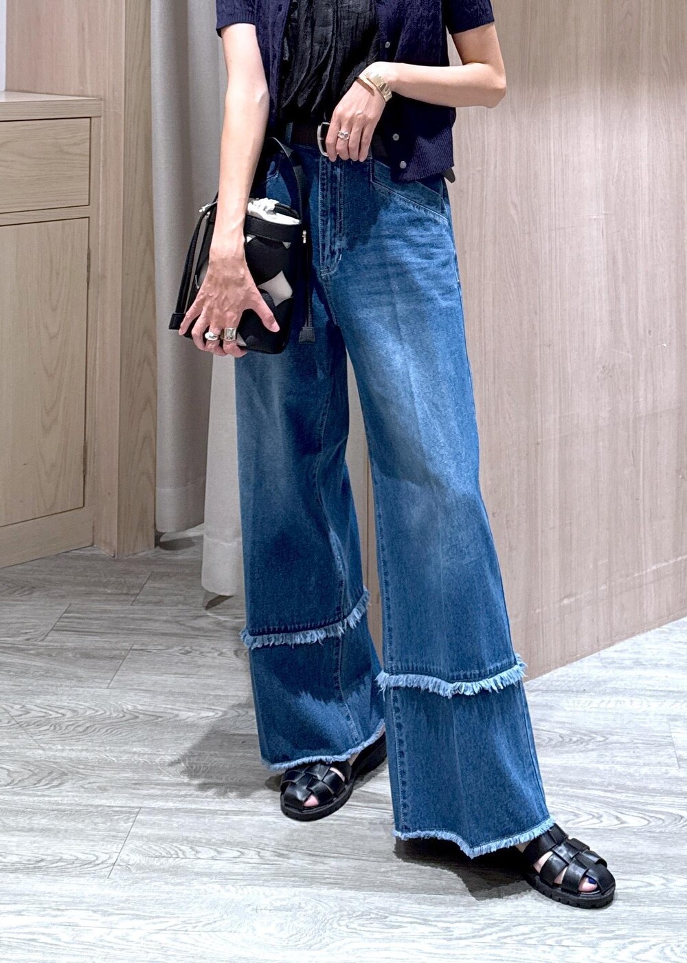 ブラック系のシャツ/ブラウス、ブルー系のカーディガン/ボレロ、ブラック系のハンドバッグを着用したレディースの夏コーディネートの5枚目の写真