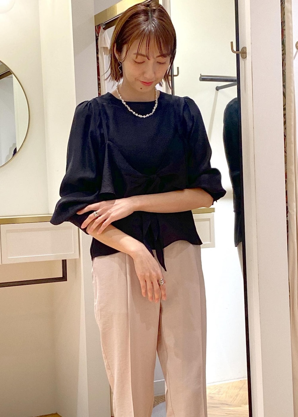 ブラック系のパンプス、ホワイト系のハンドバッグ、ブラック系のシャツ/ブラウスを着用したレディースの春コーディネートの2枚目の写真