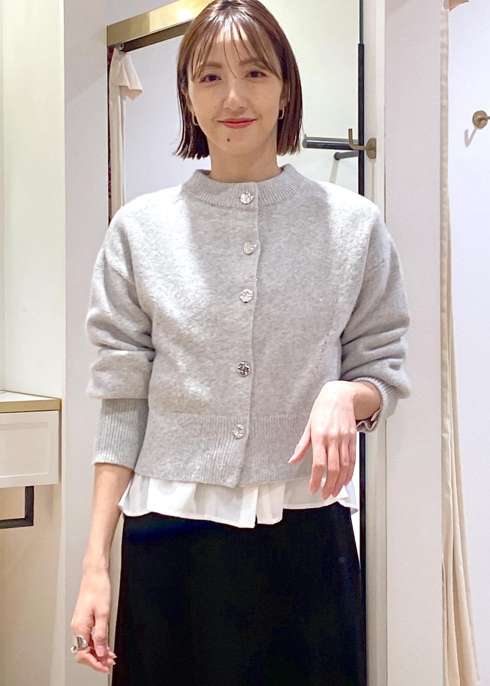 ホワイト系のシャツ/ブラウス、グレー系のカーディガン/ボレロ、ホワイト系のブーツを着用したレディースの冬コーディネートの8枚目の写真