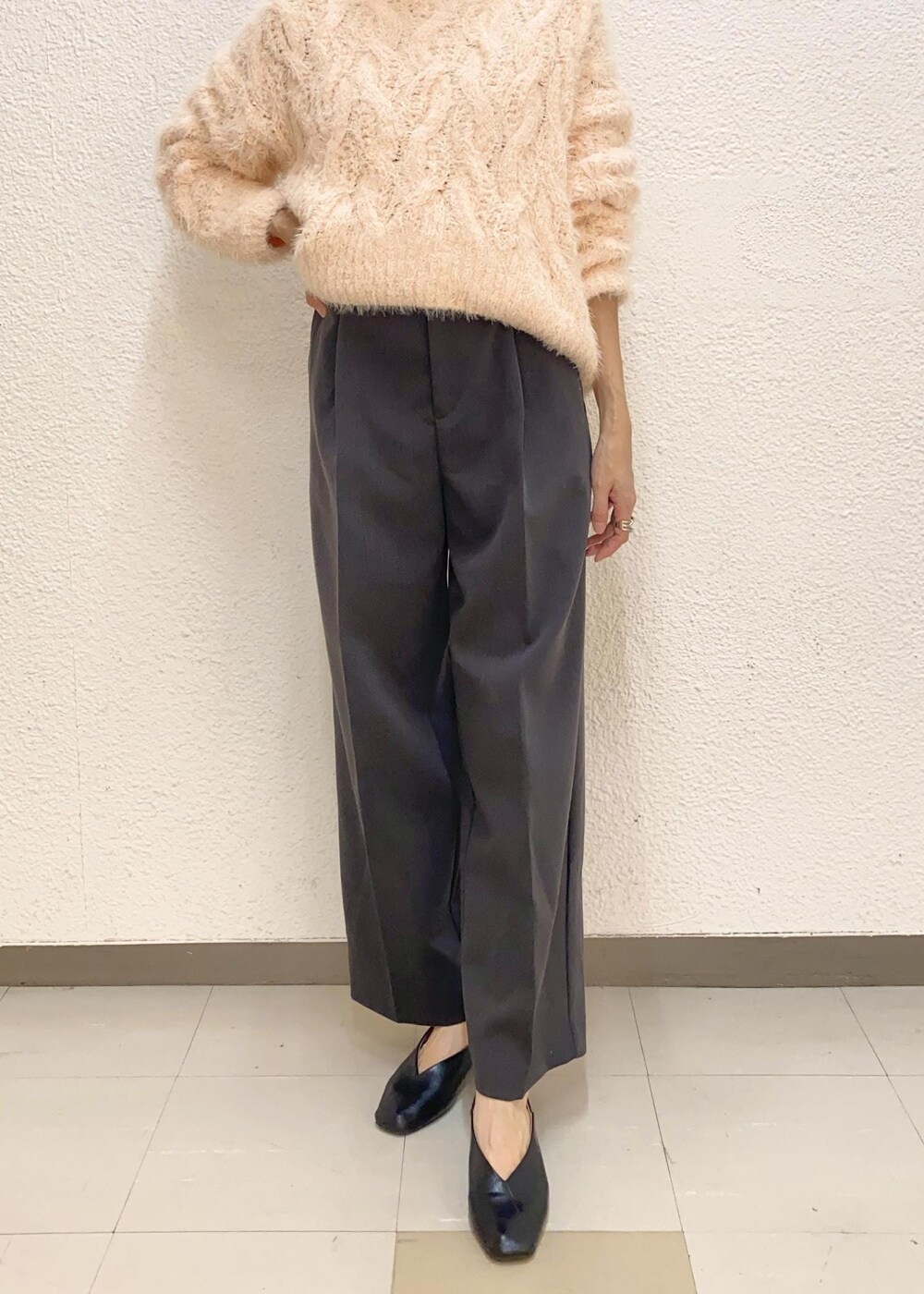 ホワイト系のショルダーバッグ、ピンク系のニット/セーター、グレー系のスラックスを着用したレディースの冬コーディネートの5枚目の写真